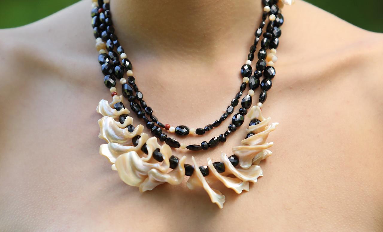 This black spinel, mother of pearl, red jasper, and silver bib necklace proves it is possible to dress up and down with great jewelry.  Style “A Little Drama