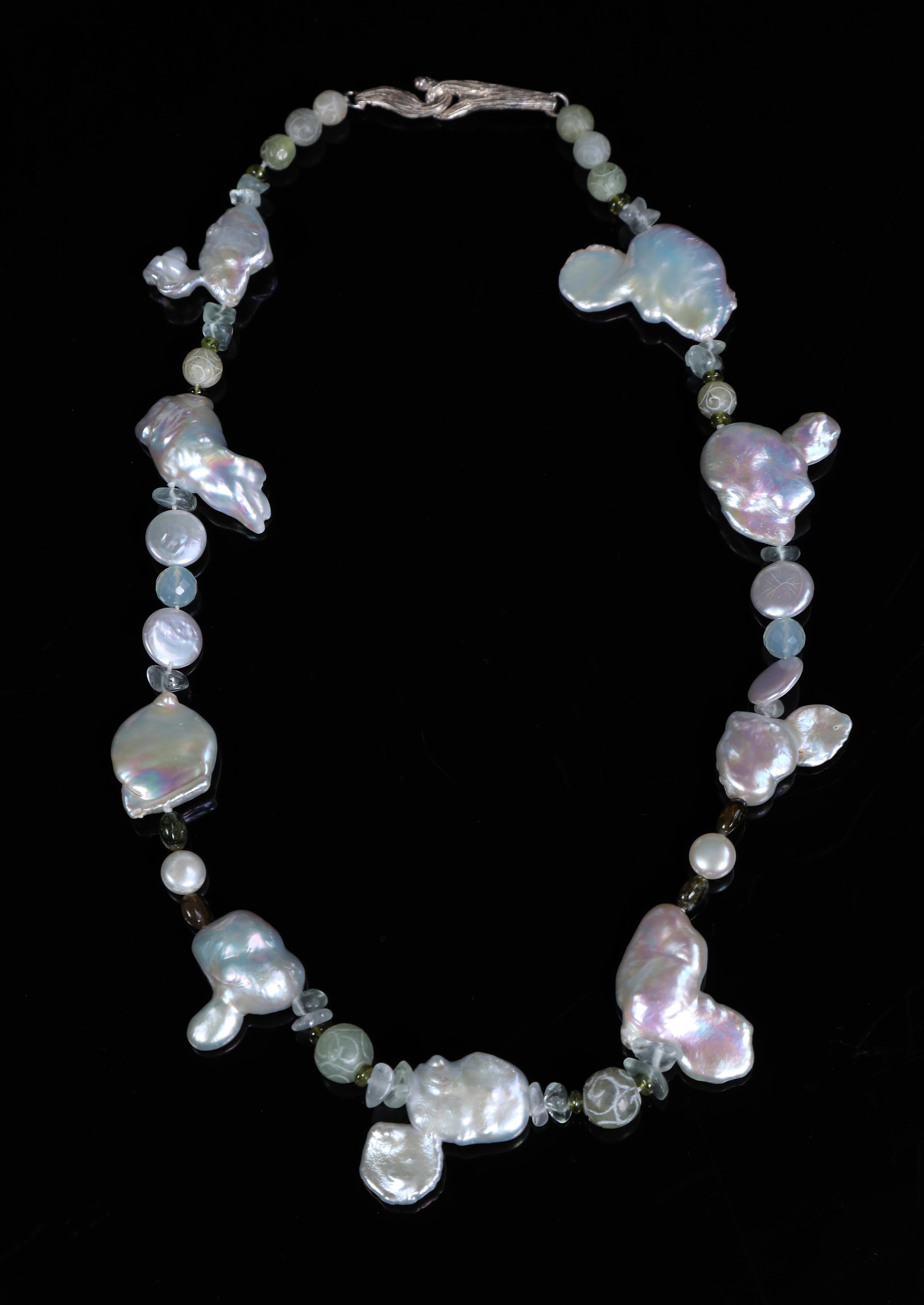 A princess necklace of Keshi pearls, matt finished carved jade, green tourmaline, and fluorite.  Our vanilla bean clasp in sterling silver brings On the Beach together. 18”