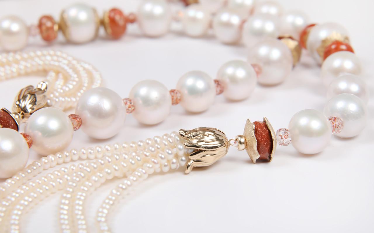 This pearl, sunstone, goldstone, and gold necklace-a  sautoir in French-continues a cherished tradition.  Centuries ago sautoirs incorporated royal insignia in celebrations.  Pearls were especially honored.  Coco Chanel modernized the look, while