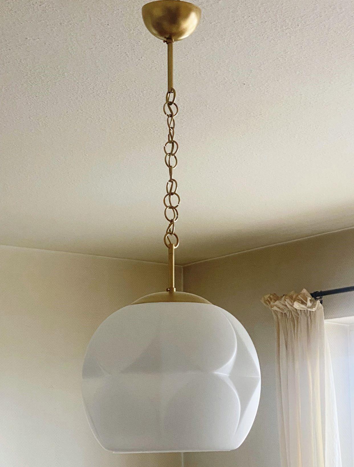 White opal glass pendant with brass mounts by Peill and Putzler, Modern Mid-Century design with organic shape, Germany, 1970s. With one porcelain light socket for a large sized Edison E27 bulb up to 100watt. This beaitiful pendant is in fine vintage