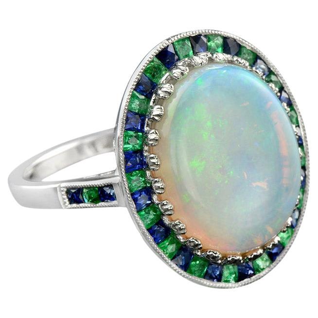 White Oval Cabochon Opal with Emerald & Sapphire Fancy Halo Set White Gold Ring For Sale
