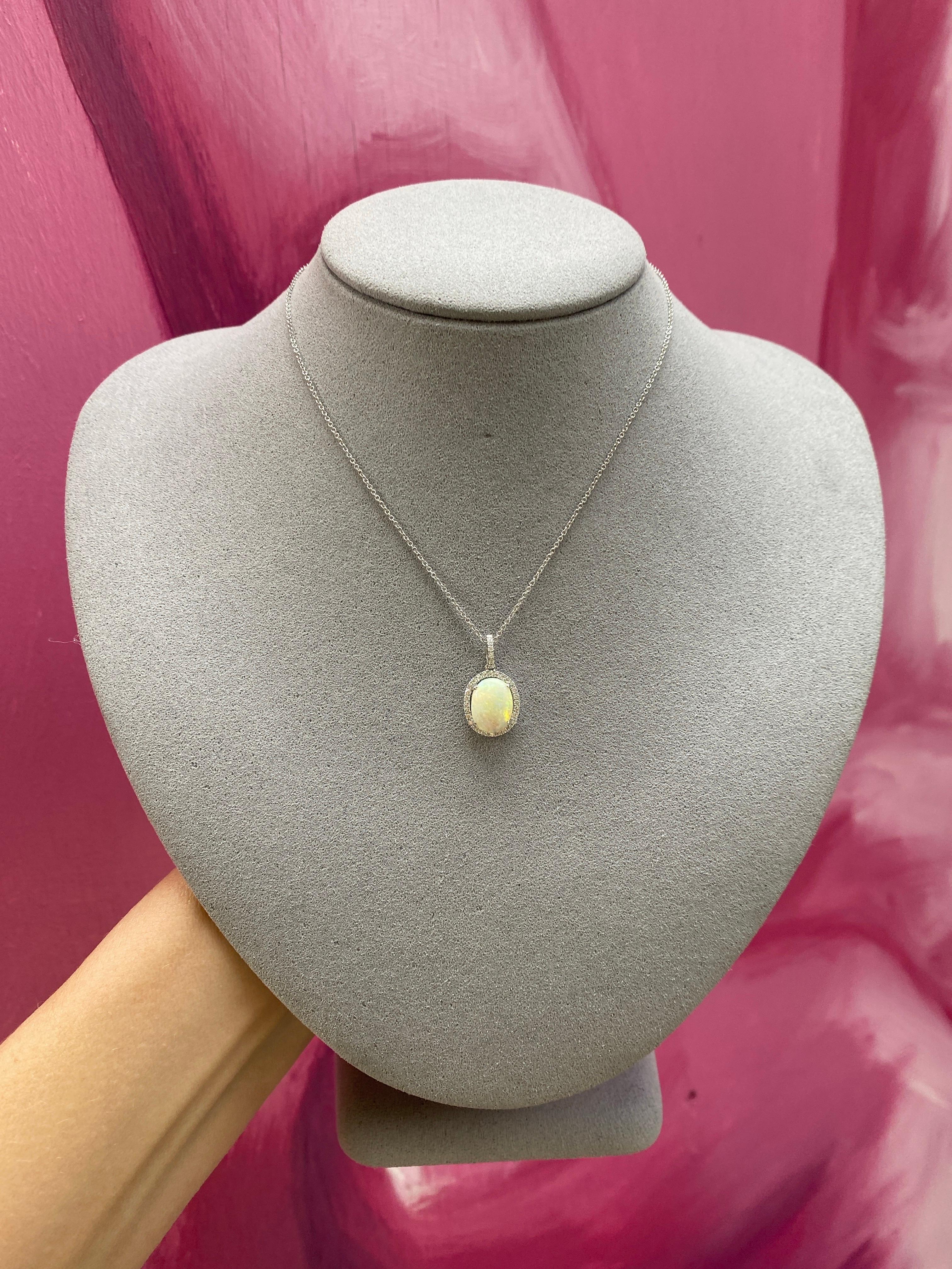 This exquisite pendant features a mesmerizing white oval opal surrounded by a halo of 0.21 carats of brilliant diamonds, creating a captivating blend of elegance and luxury. Crafted in premium 18 karat white gold and designed to hang beautifully at