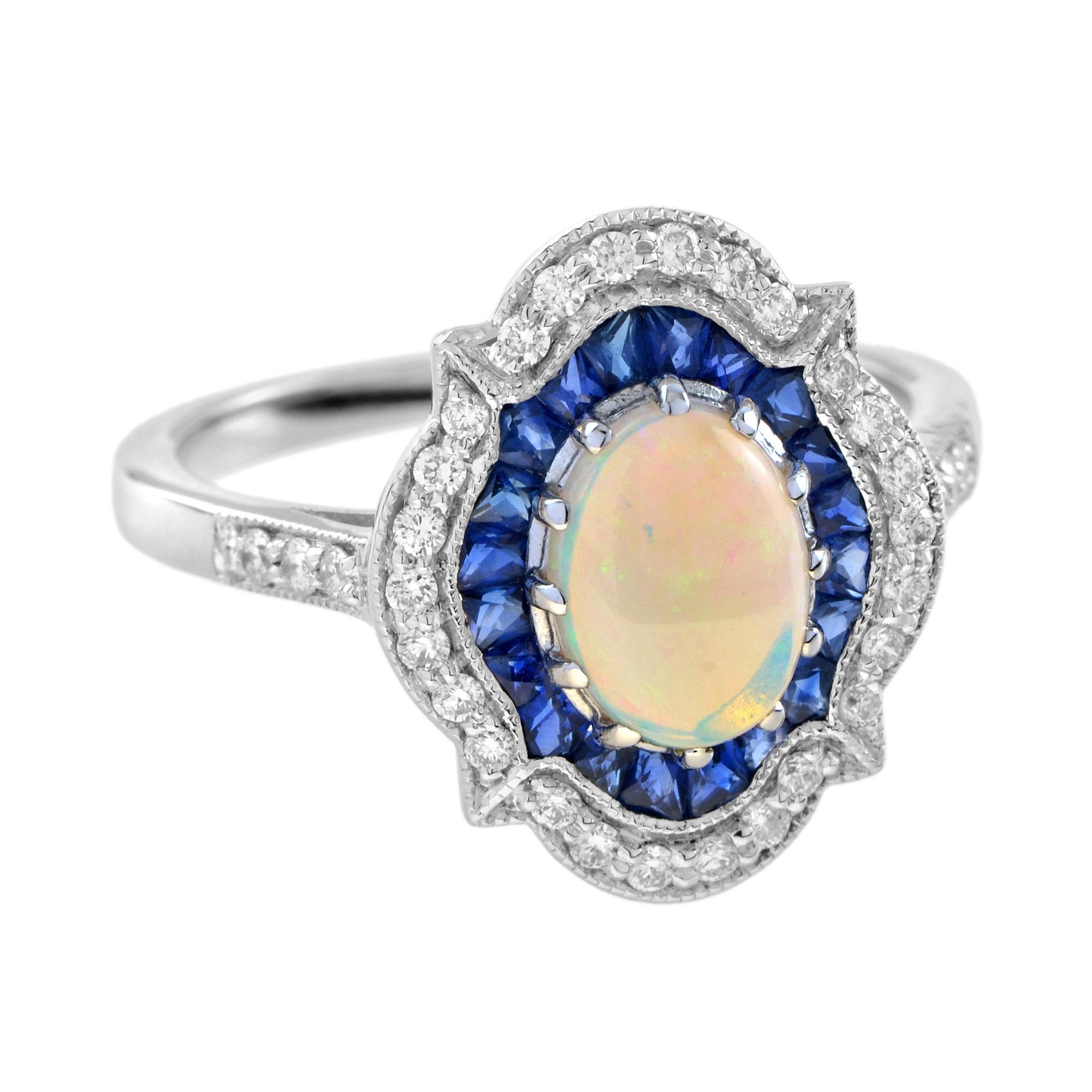 Un anello a grappolo con opale, zaffiro e diamante assolutamente unico e dal design eccezionale. Al centro è incastonato un magico opale naturale con sfumature arcobaleno. L'opale è circondato da un'aureola di zaffiri blu taglio francese e diamanti