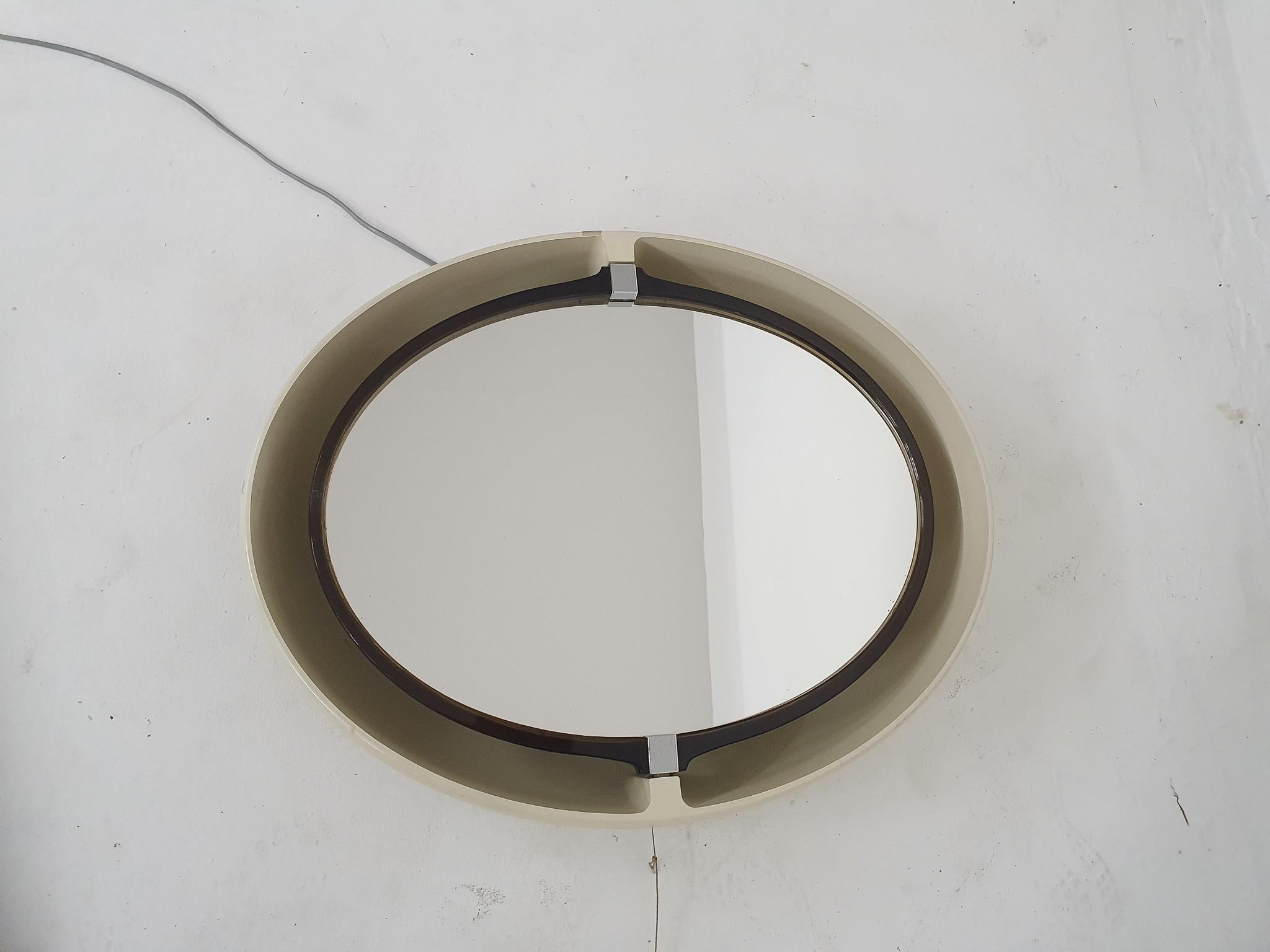 White plastic pivoting mirror with back light. A small chip from the inner plastic edge.