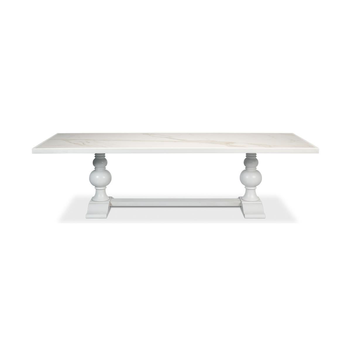 Table de salle à manger avec un plateau incrusté de porcelaine Calacatta, sur une base à double piédestal en forme de balustre tourné, avec une finition peinte à la main en blanc.

Dimensions : 108