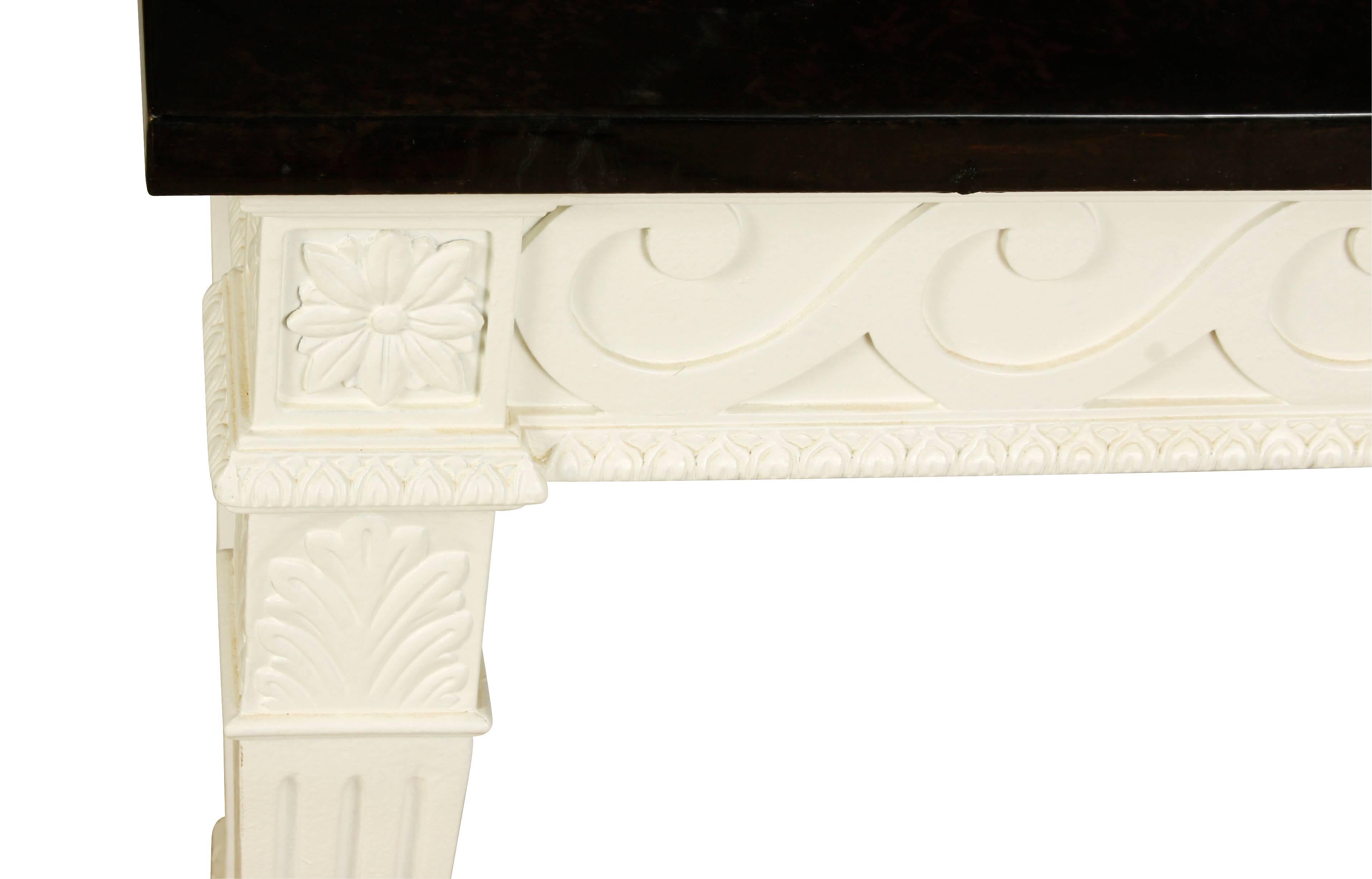 White painted carved console with faux marble top and Vitruvian scroll frieze.