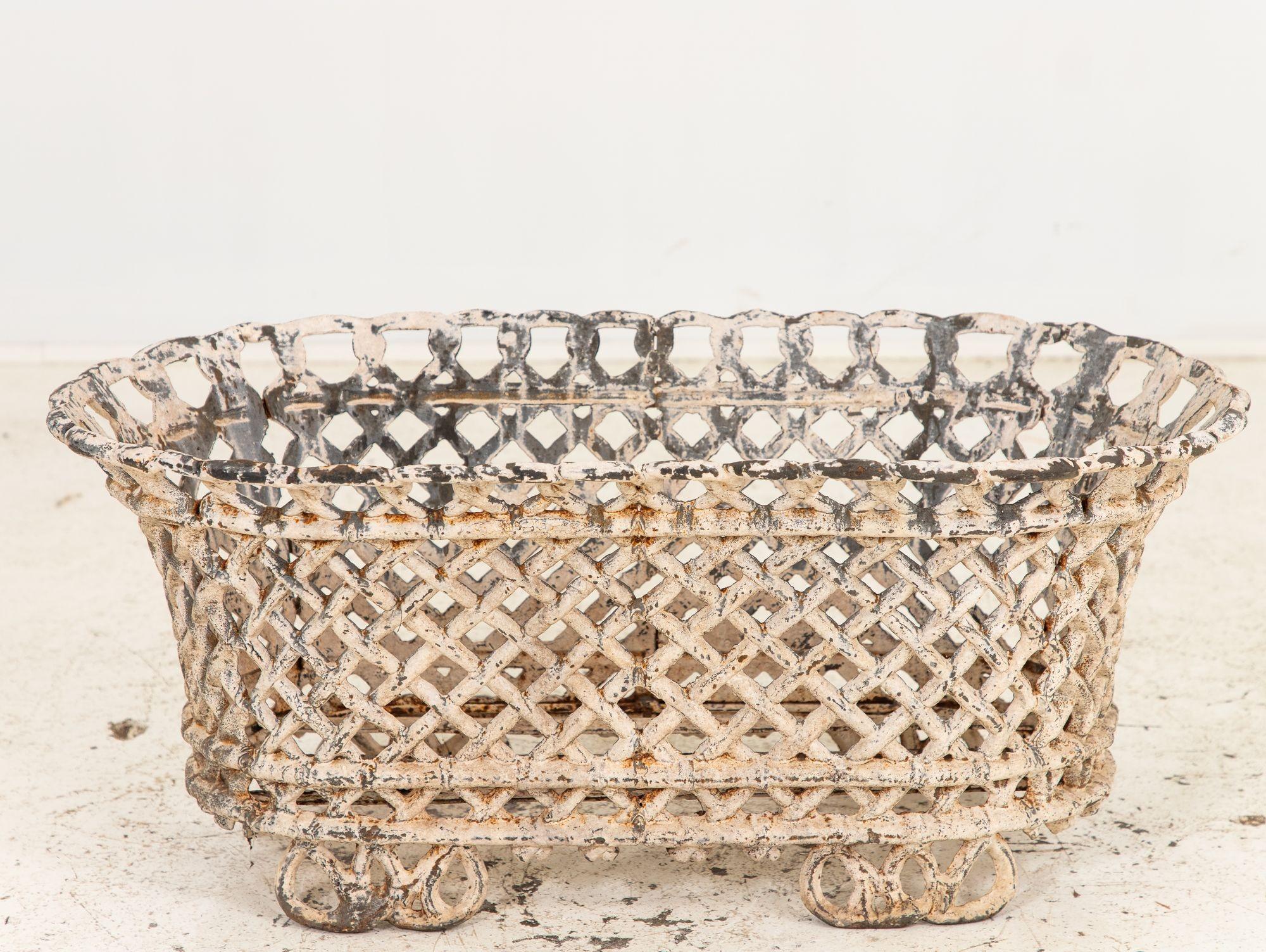 This early 20th-century French treasure is a White Painted Cast Iron Lattice Work Basket, exuding timeless elegance and craftsmanship. Crafted with meticulous artistry, the delicate latticework exhibits intricate detailing, showcasing the mastery of