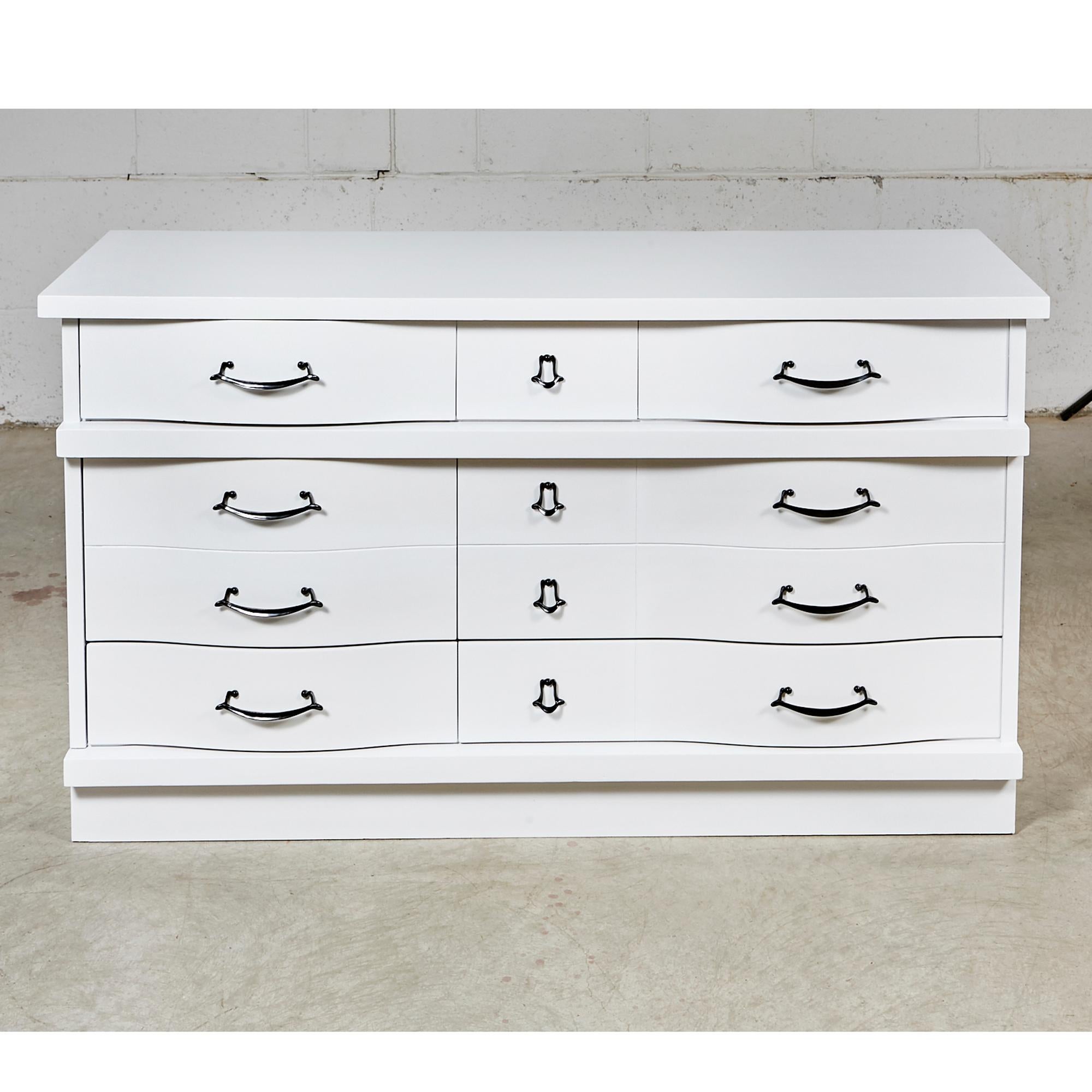 Vintage 1960s white painted three-drawer dresser with black painted pulls. Middle drawer is doubled in size. Newly refinished condition.