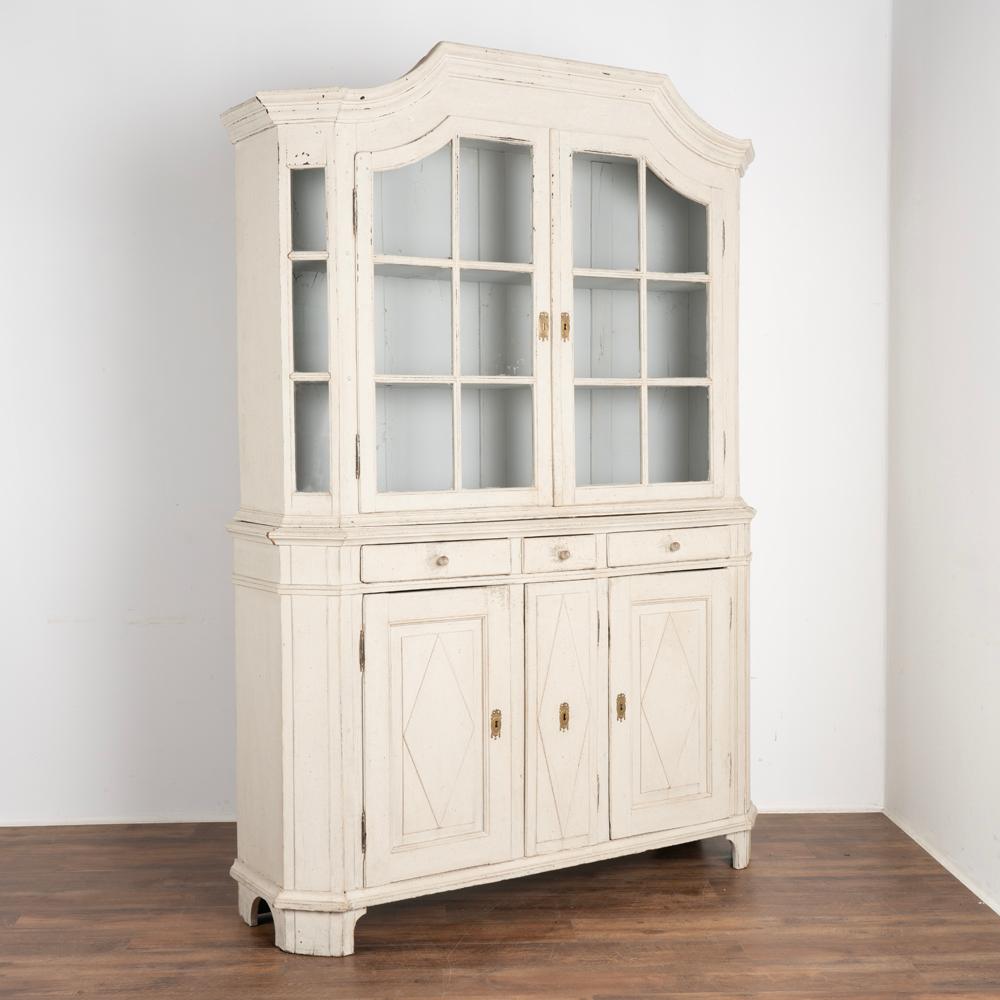 This delightful Gustavian display cabinet has both beautiful and functional storage options.
The upper cupboard with glass panes in the two doors and even canted sides allows one to attractively display any collection held within. The configuration