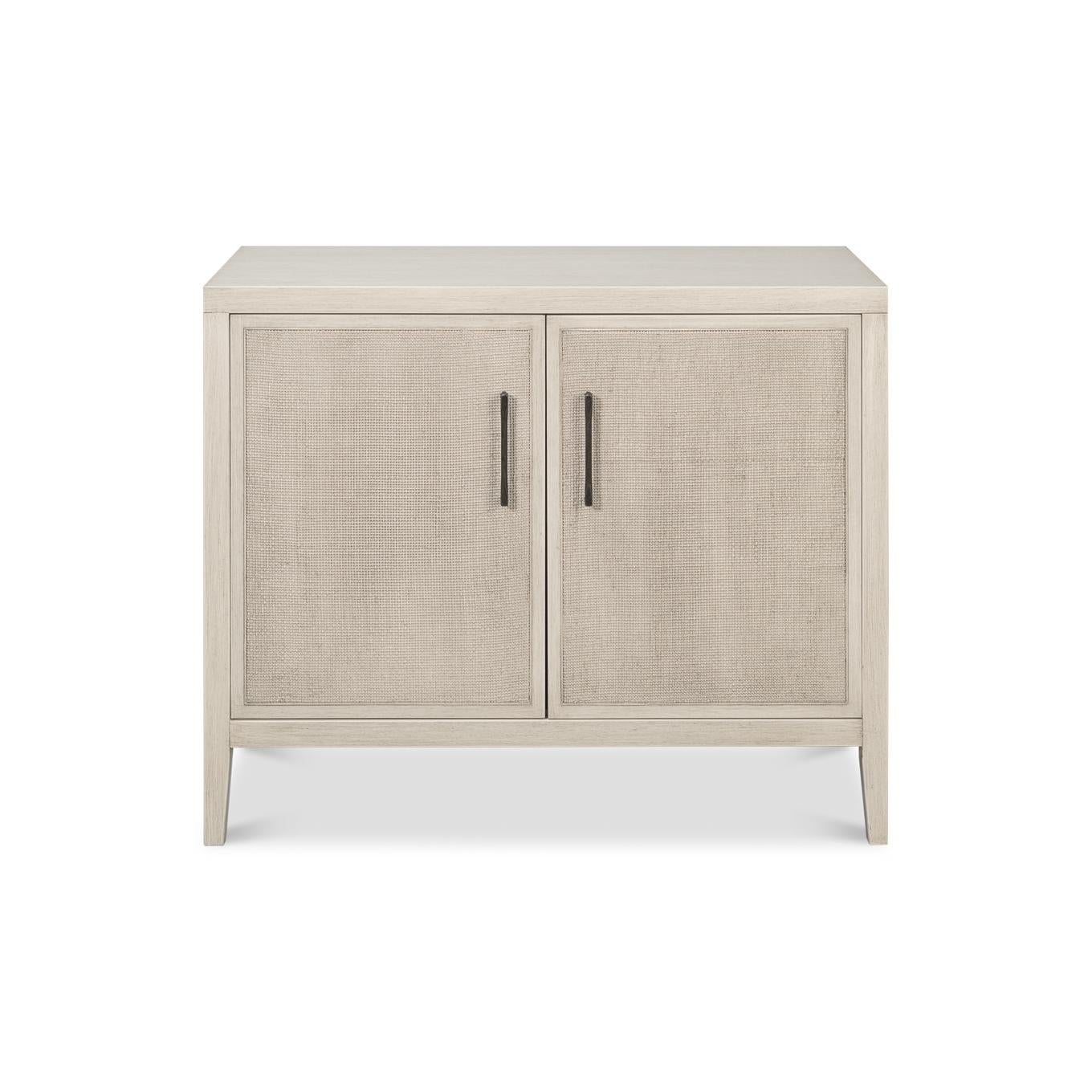 Fabriqué en chêne avec une finition blanche douce, il offre un look minimaliste. Les portes à panneaux de canne ajoutent de la texture, tandis que les poignées métalliques élégantes offrent un beau contraste. Derrière ses doubles portes, de nombreux