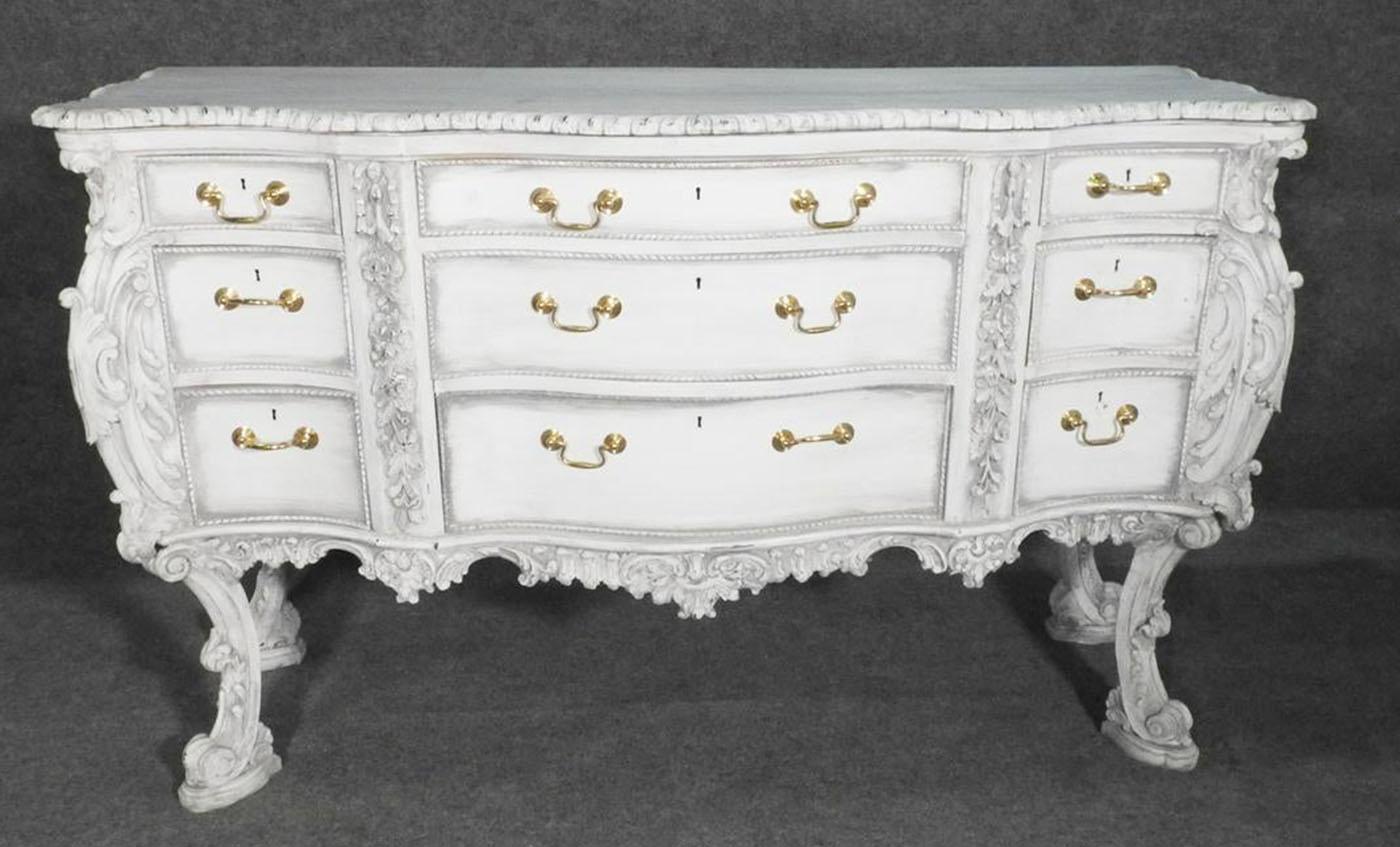 Serpentine top over conforming case. 9 drawers. Metal hardware. Painted. Carved. Measures: 37 3/4