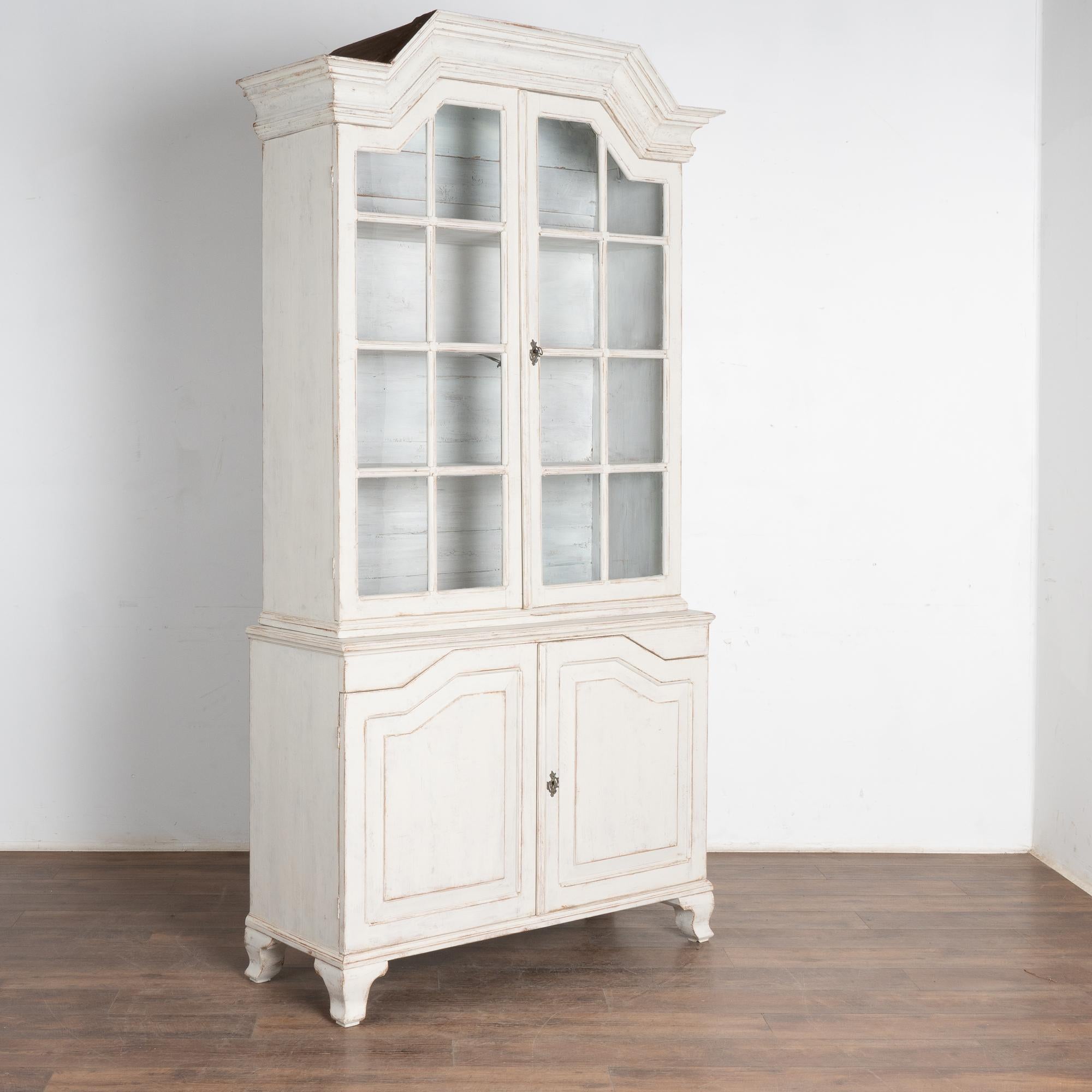 Este armario de pino rústico europeo puede utilizarse como vitrina o librería. Las puertas de cristal superiores permiten exponer de forma ideal cualquier colección que se guarde en su interior, y son lo suficientemente profundas como para alojar