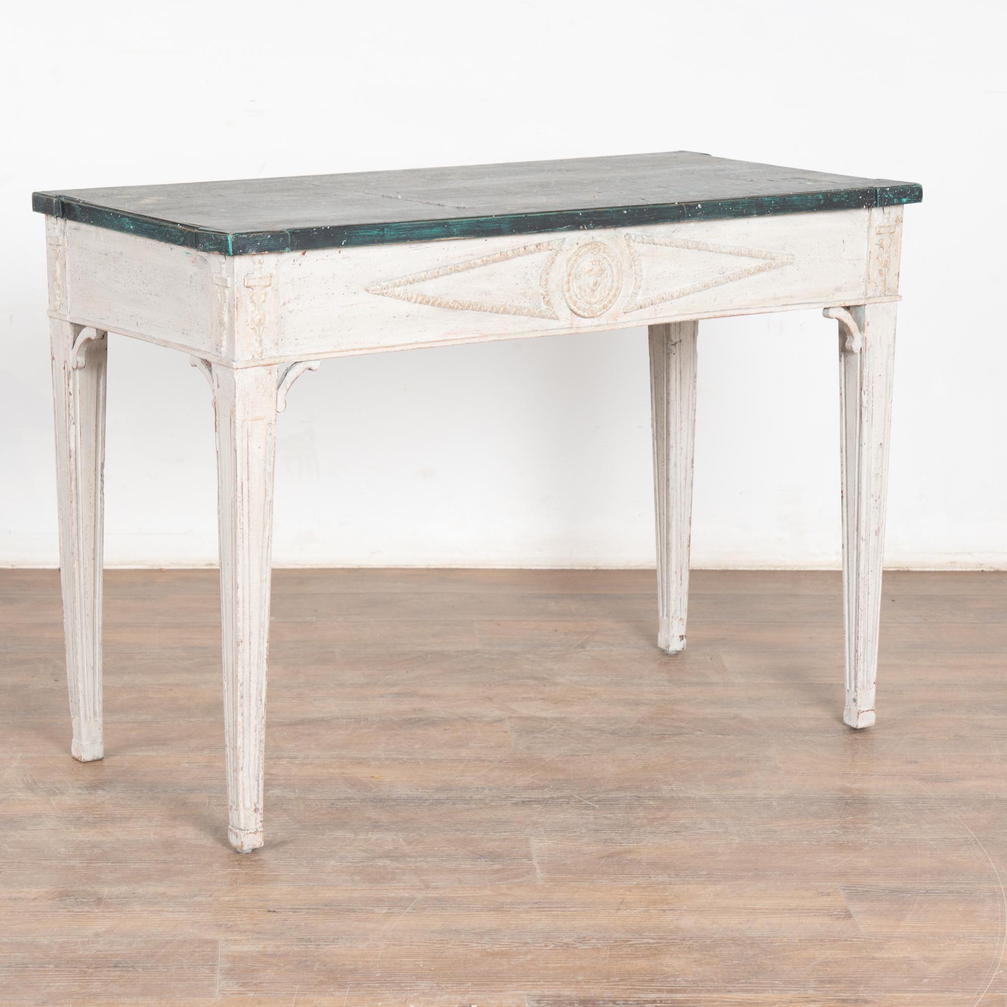 Swedish Gustavian style side table, may also be used as a small desk. 
Lovely tapered fluted legs with applied carved embellishments along the skirt add to the romantic grace of this pine side table.
Restored, later professionally painted in layered