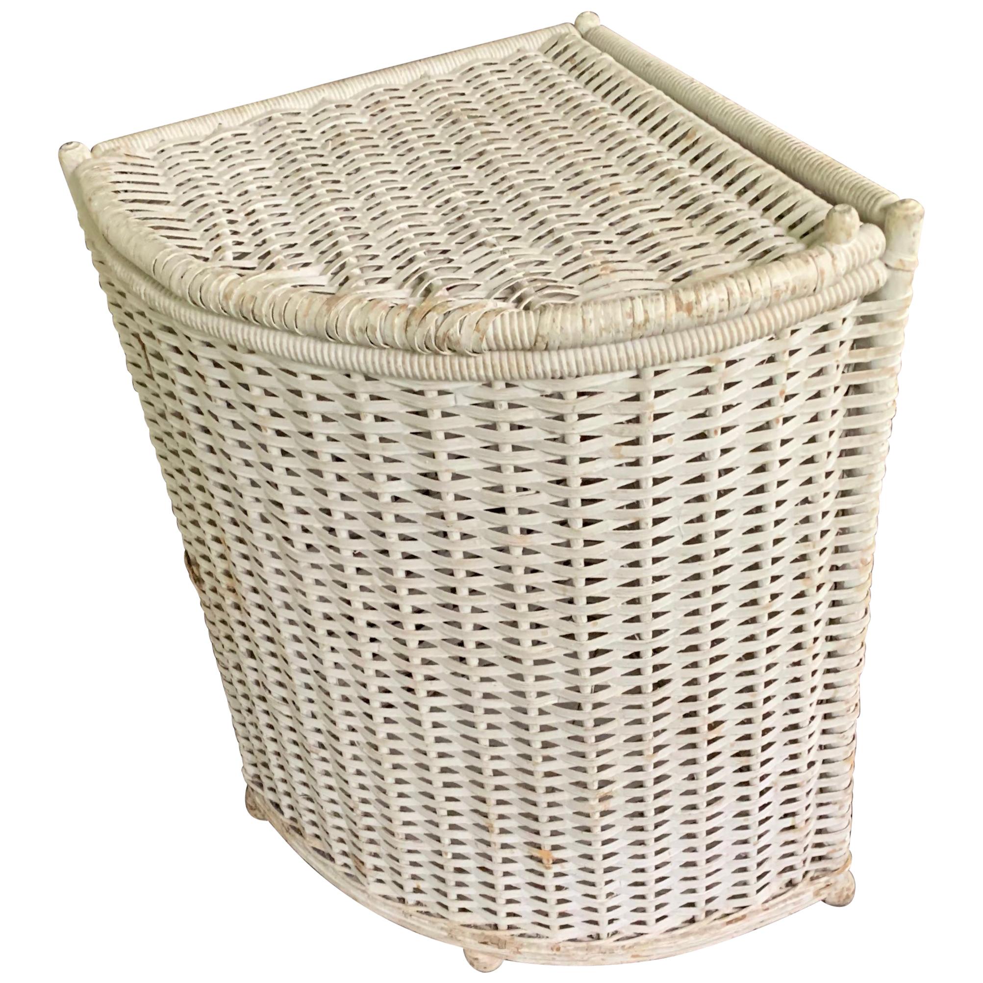 White wicker corner hamper. Vintage angled woven wicker laundry hamper with lid on ball feet perfect for a corner in the bath or on the porch. American, 1920s.
Dimensions: 14