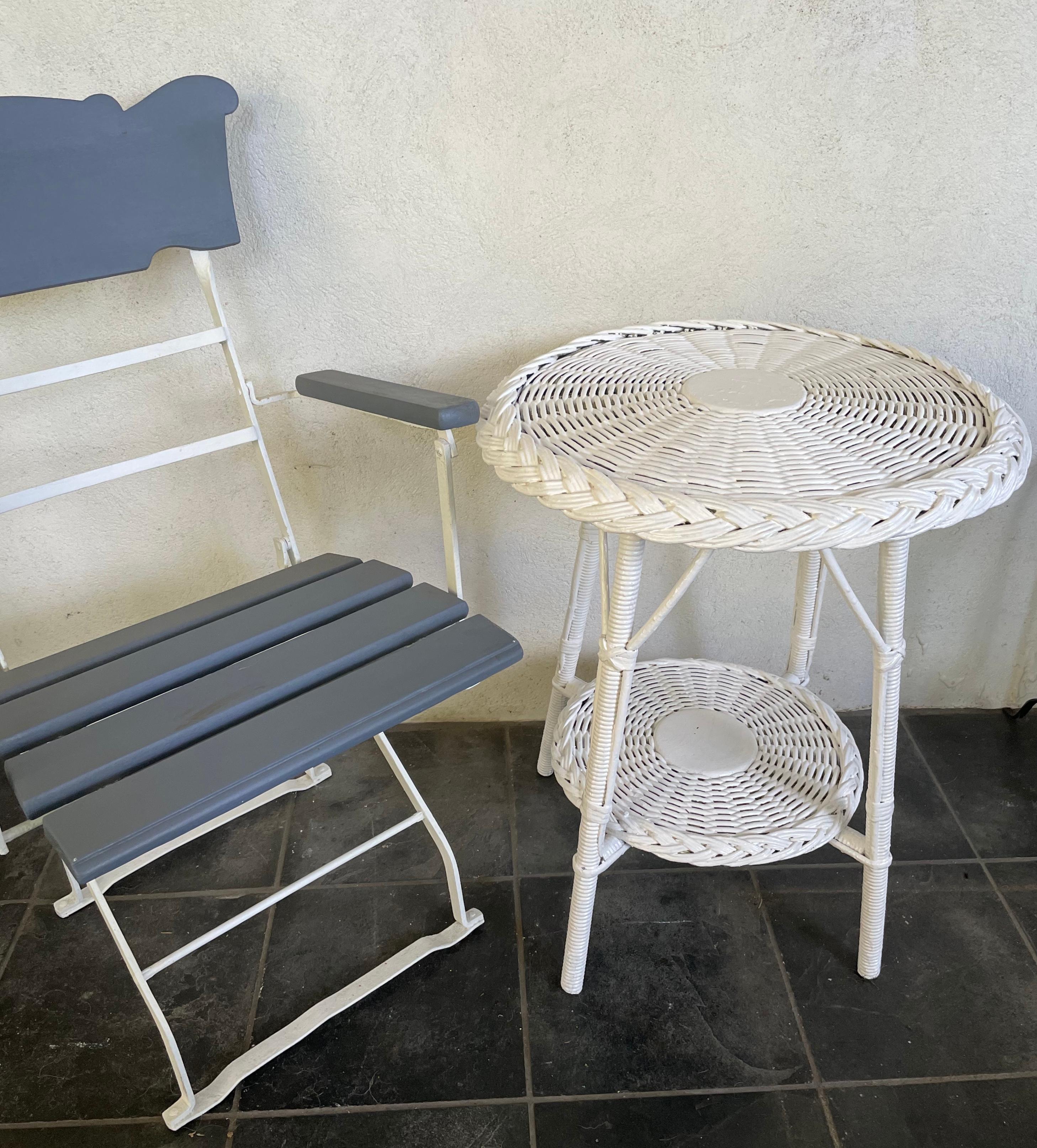 White Wicker side table. Vintage American sturdy round wicker side table with conforming tray stretcher below. In very good condition. United States, first quarter of 20th century. 
Table 21” diameter x 26” height x 21” base.