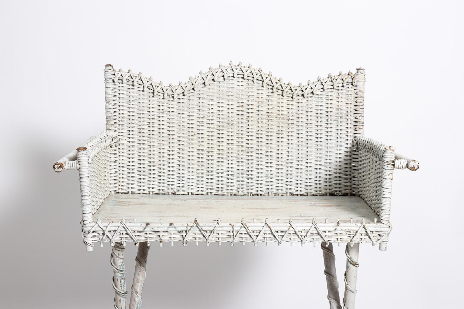 White painted wicker woven washstand with bottom stretcher, circa 20th century. Please note of wear consistent with age including minor paint loss and wear to the wood tabletop.