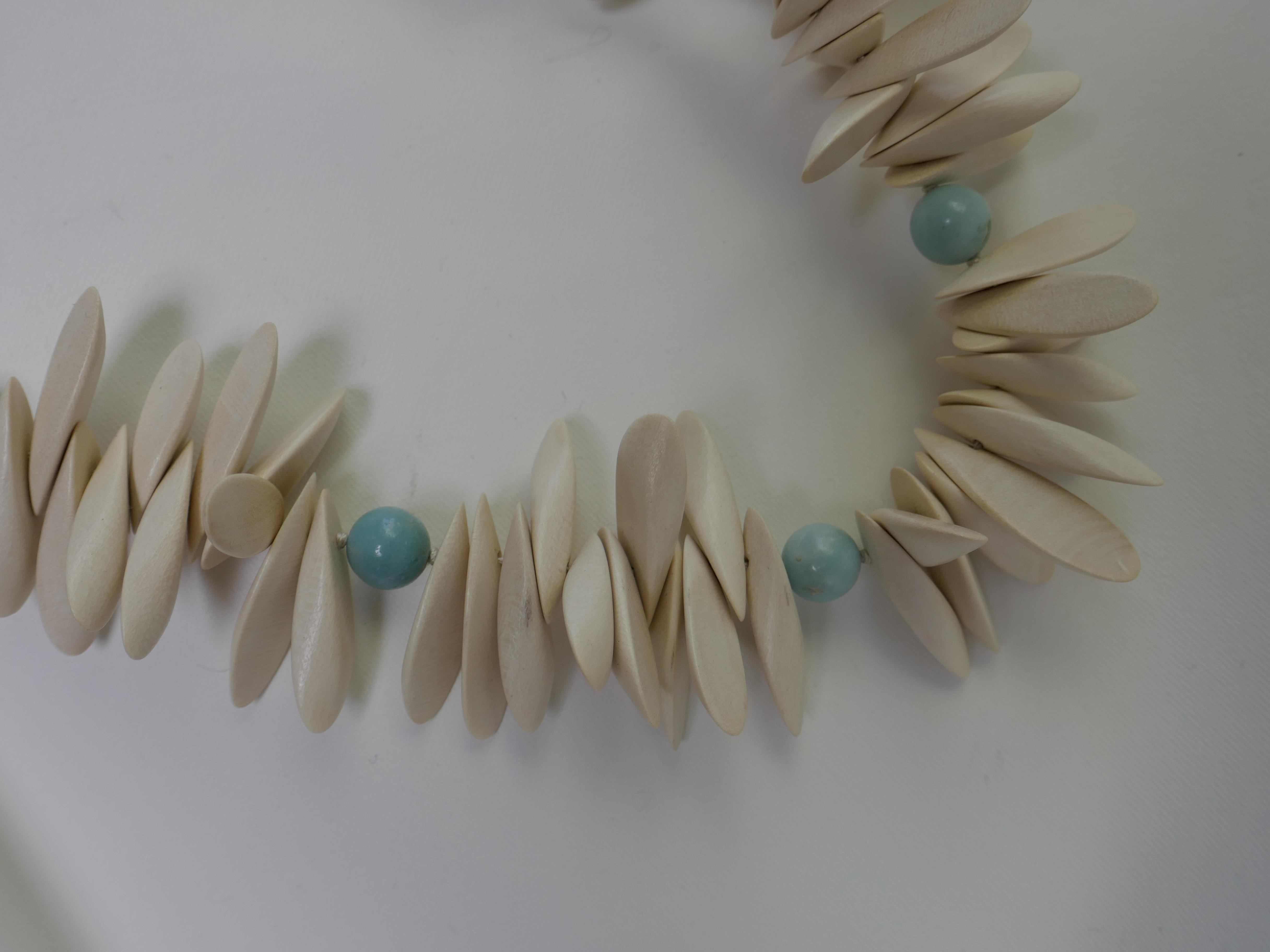 This necklace is a combination of white panto wood beads and 10mm amazonite beads with a 925 sterling silver closure. It is a very wearable necklace, unusual and fun. It is knotted silk thread. The necklace was designed and created by Lucy de la