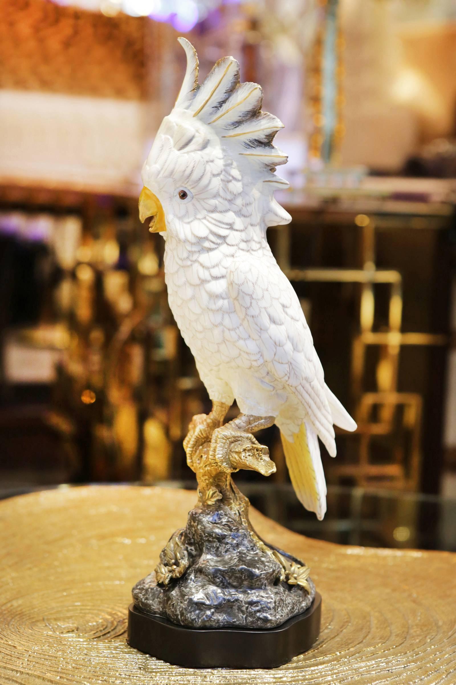 Sculpture white parrot all handcrafted in
porcelain. Hand-painted and with details
in solid bronze.
 