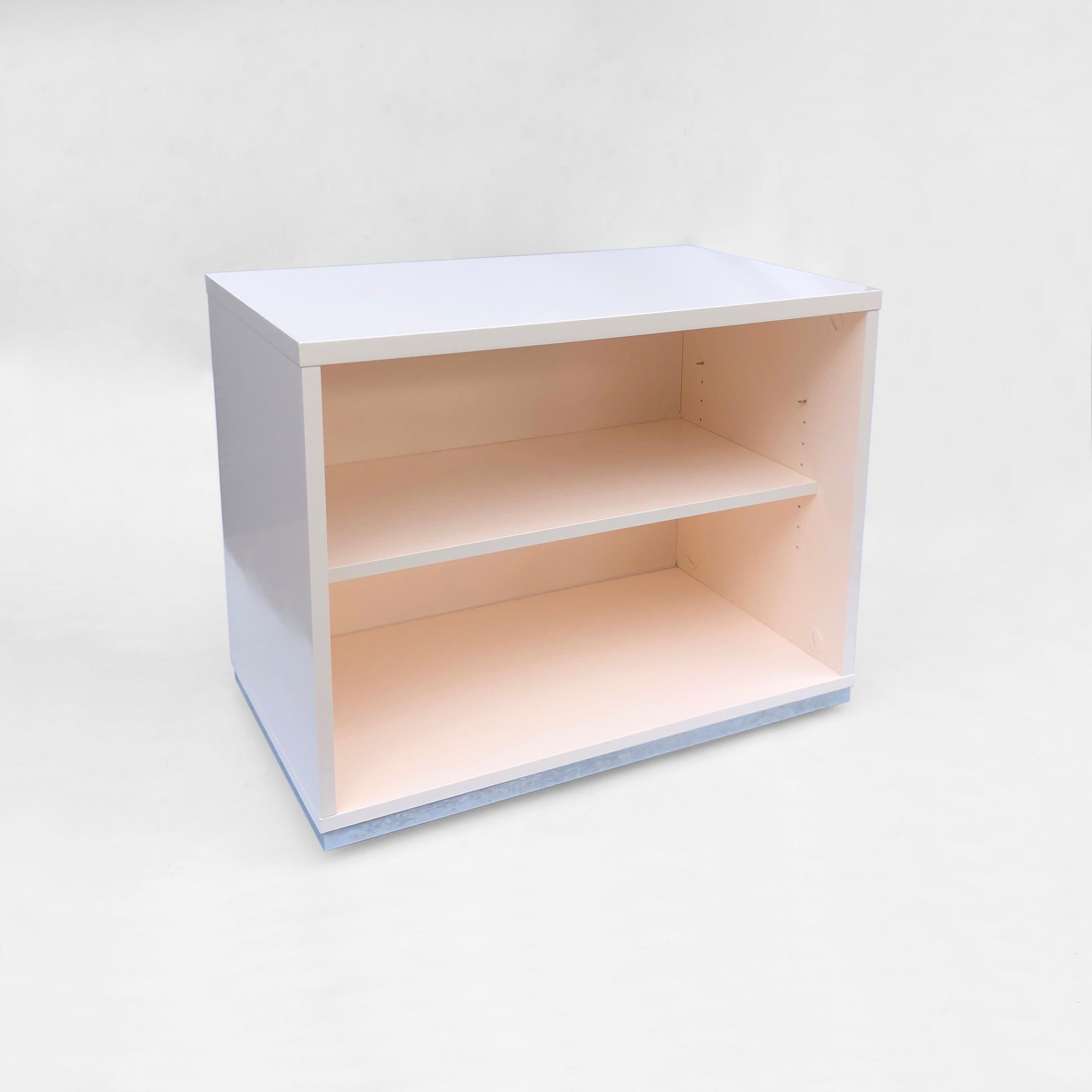 A knee-high, minimal bookshelf – perfect for the study, bedroom, or any room where you want to add a sleek and chic storage solution. This piece consists of four caster wheels, hidden by a chrome base, atop which sits a wooden shelving unit,