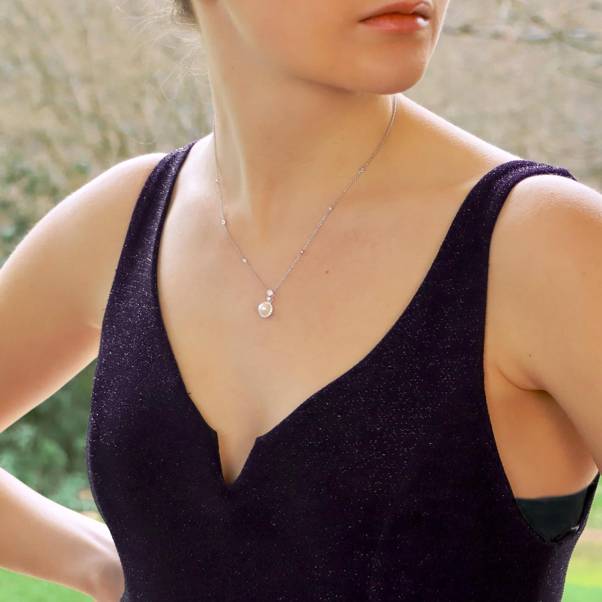 A fabulous little pearl and diamond pendant necklace set in 18k white gold.

The pendant prominently features a 9mm white cultured pearl which hangs from a rubover set round brilliant cut diamond. This single diamond is then suspended from a