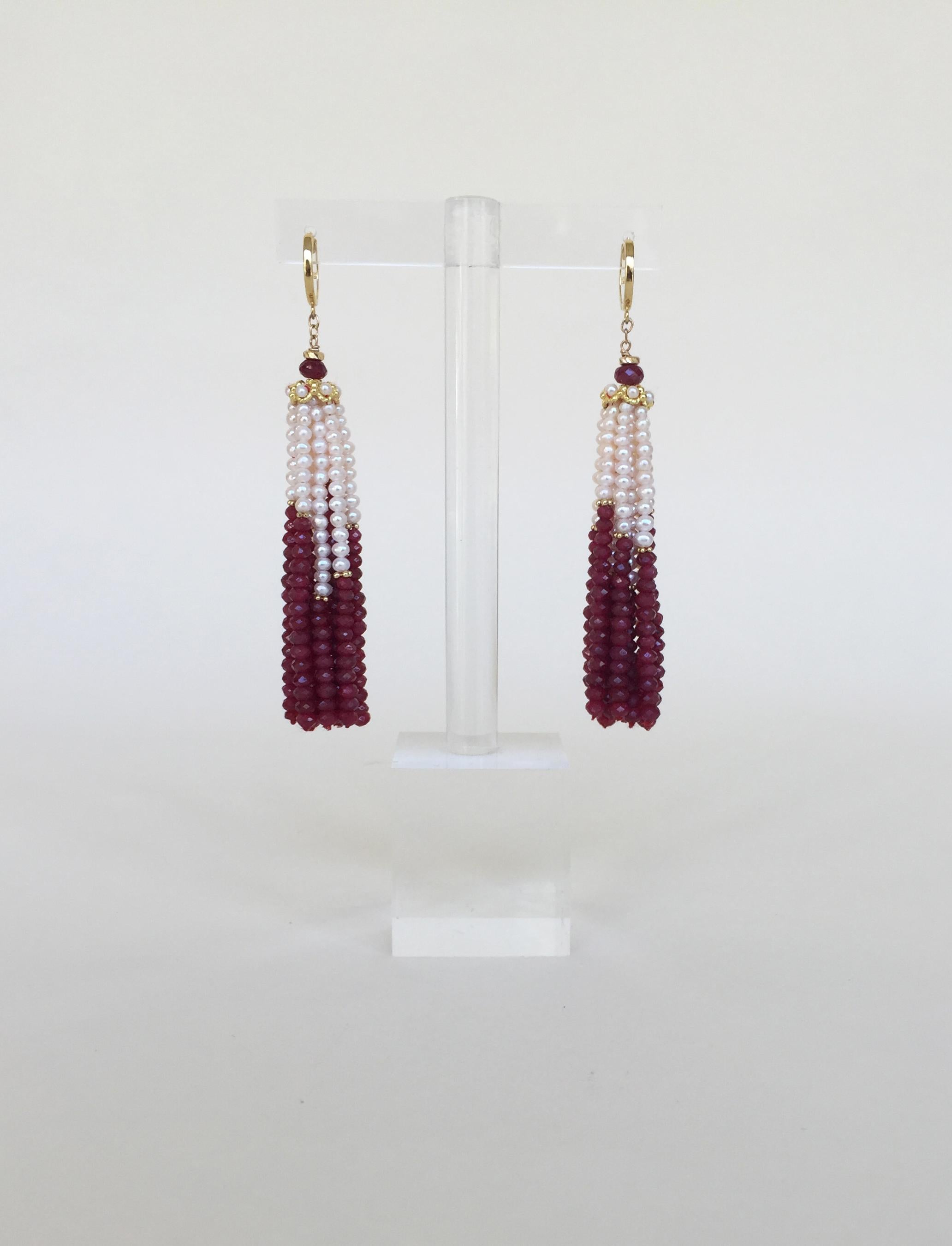 These white pearl and ruby graduated tassel earrings with 14k yellow gold lever backs are gorgeous with glowing white pearls and rich red ruby beads. The tassel starts with white pearls and small 14k yellow gold dividers, and finishing with