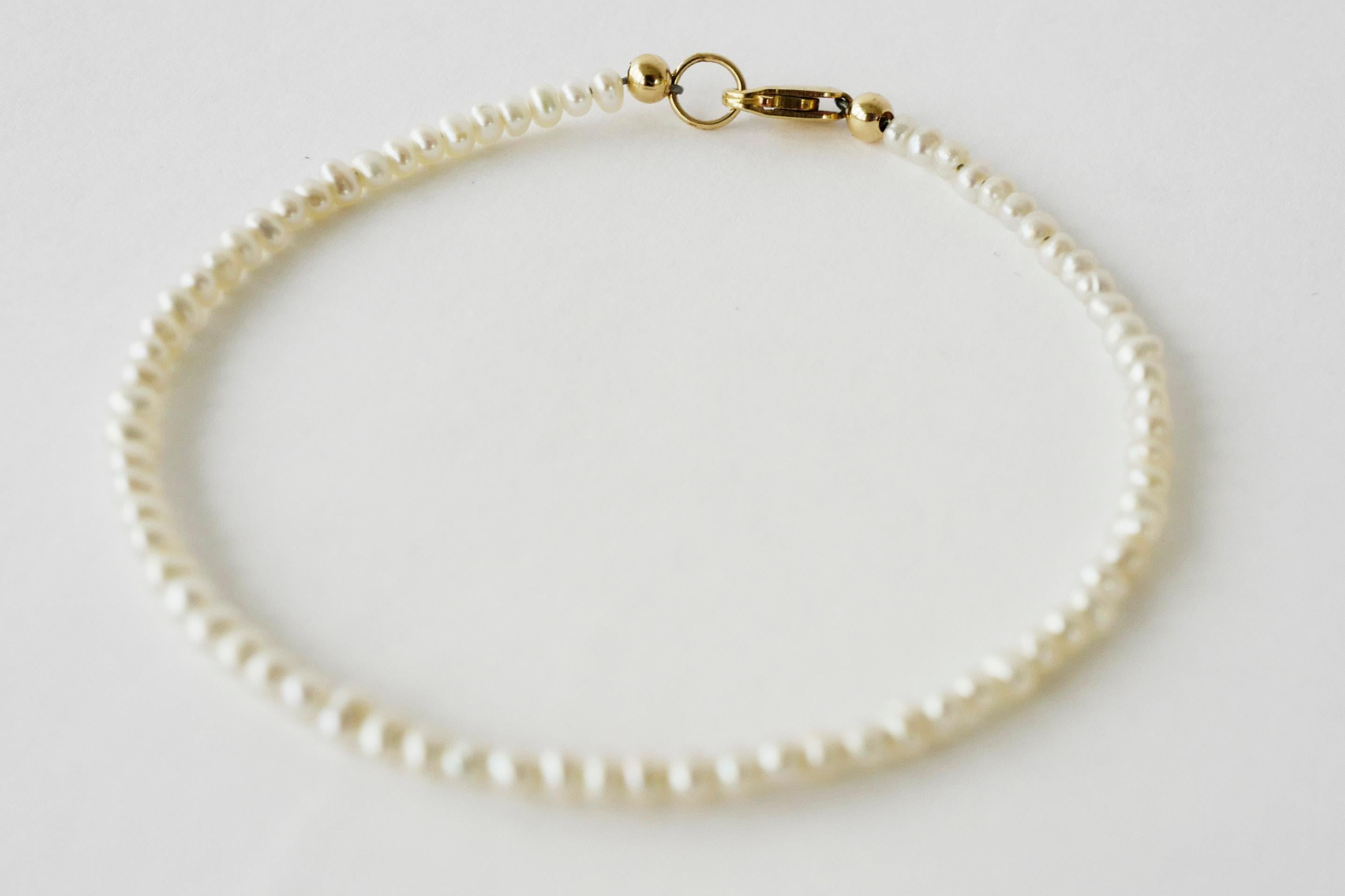 Bracciale di perle bianche 

Progettista: J Dauphin

Metallo: Riempito d'oro

