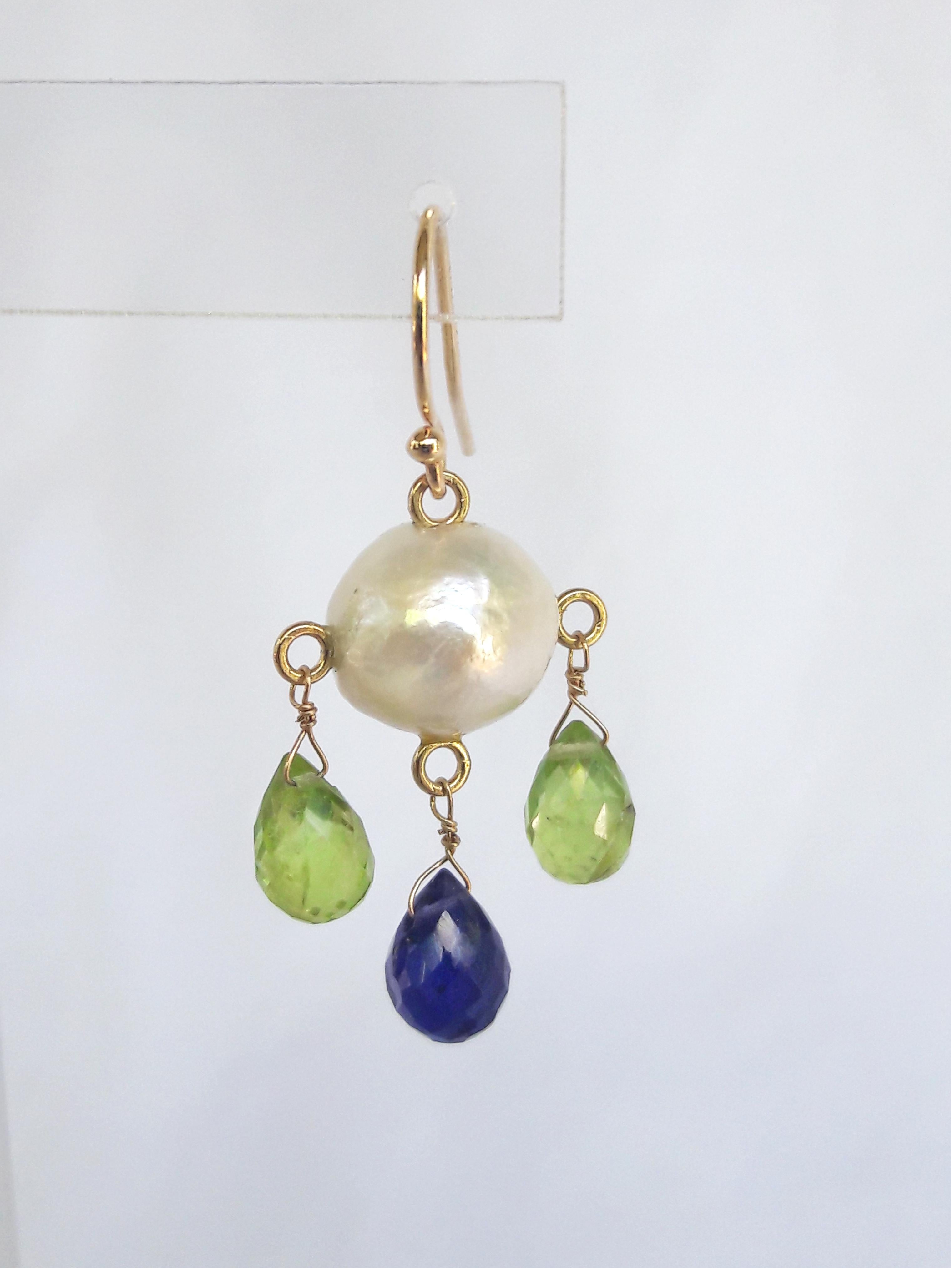 These white pearl earring with iolite and peridot drops and 14k yellow gold hooks are hand made by Marina J. The round white pearl is beautiful with slight imperfections that add to the detail of these earrings. Hanging from the white pearl are