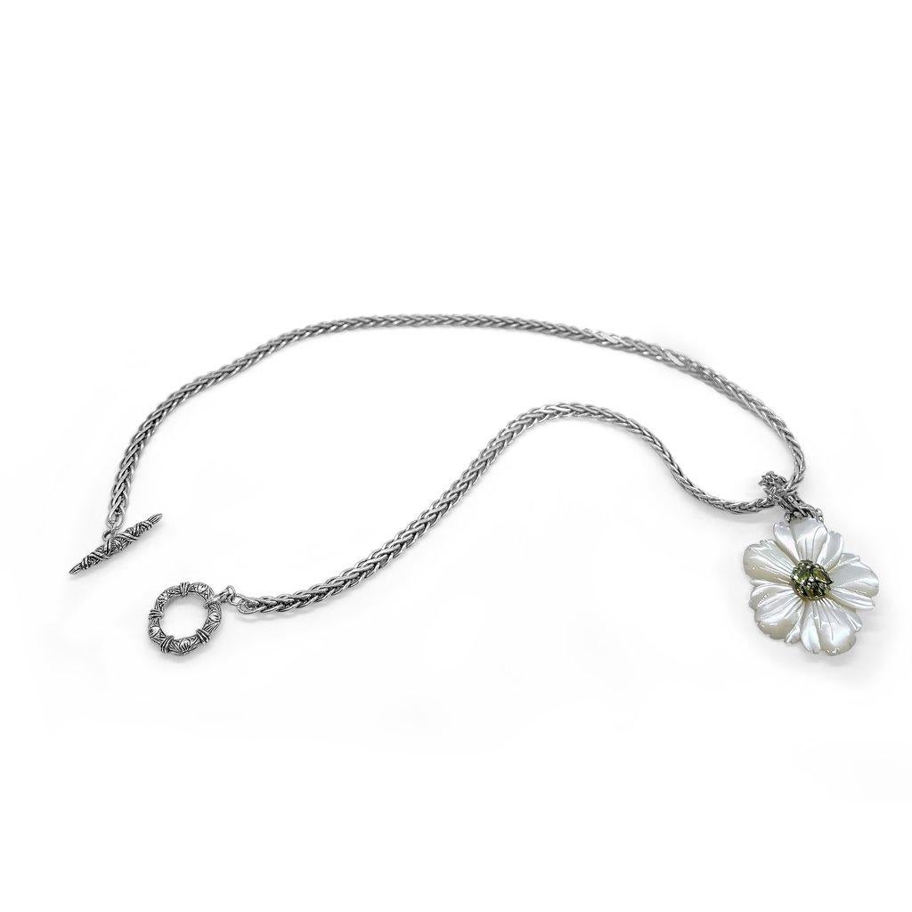 Fiore di madreperla bianca con gemma di peridoto al centro e piccolo fermaglio inciso in argento sterling

Il fiore sempre sbocciato, immortalato per sempre in questa collezione, è senza tempo e va indossato in tutte le stagioni. La madreperla