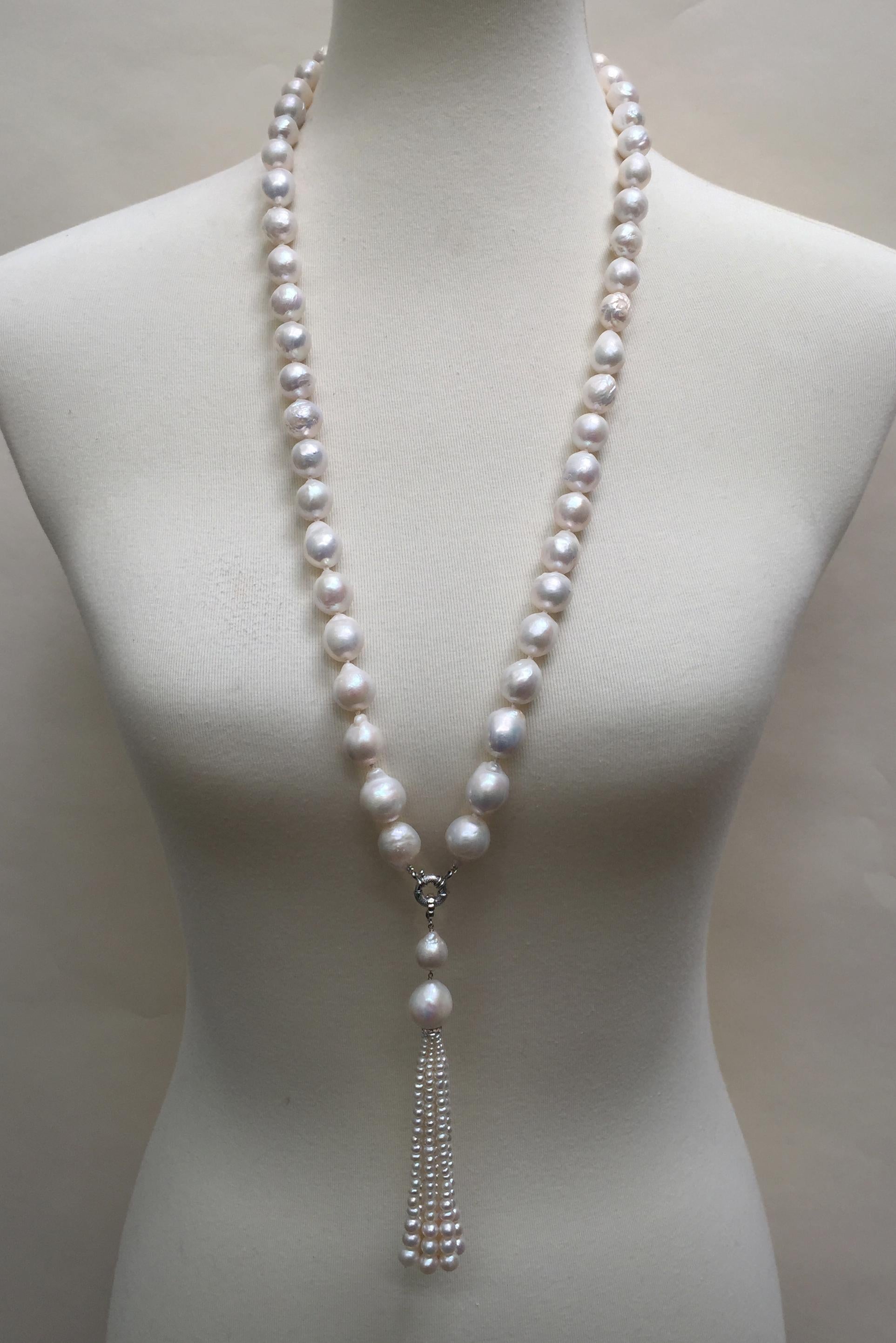 This white pearl necklace has a removable double pearl graduated tassel with a 14k white gold clasp.The necklace is composed of baroque pearls (10-15 mm). It's tassel starts with 12 and 19 mm pearl, respectively. The tassel is accented with