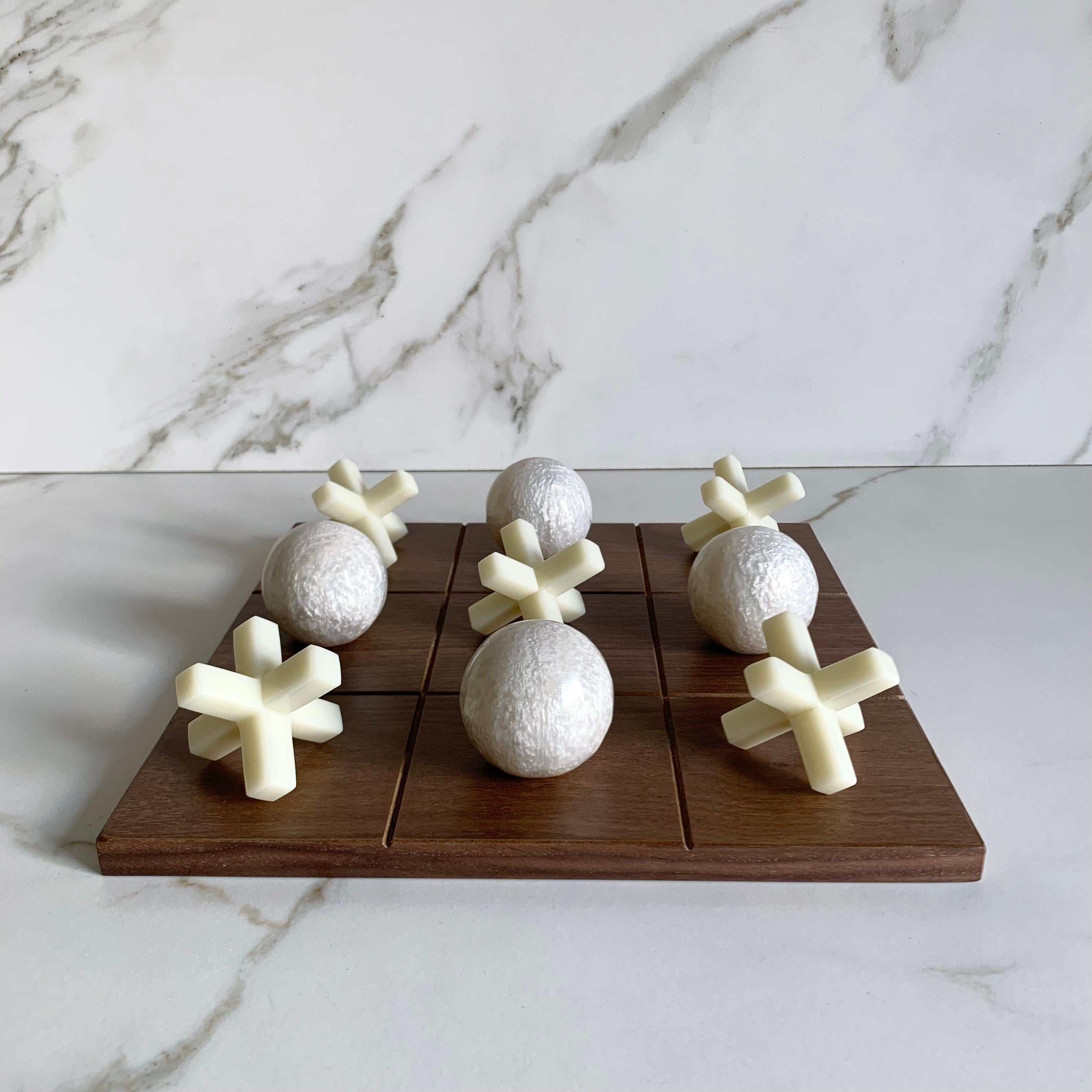 Our Tic Tac Toe is a beautiful, modern and fun take on the classic game. The three dimensional pieces are handmade in white pearl & ivory and the board is made of oak wood veneer. It will be the coolest statement piece on any coffee