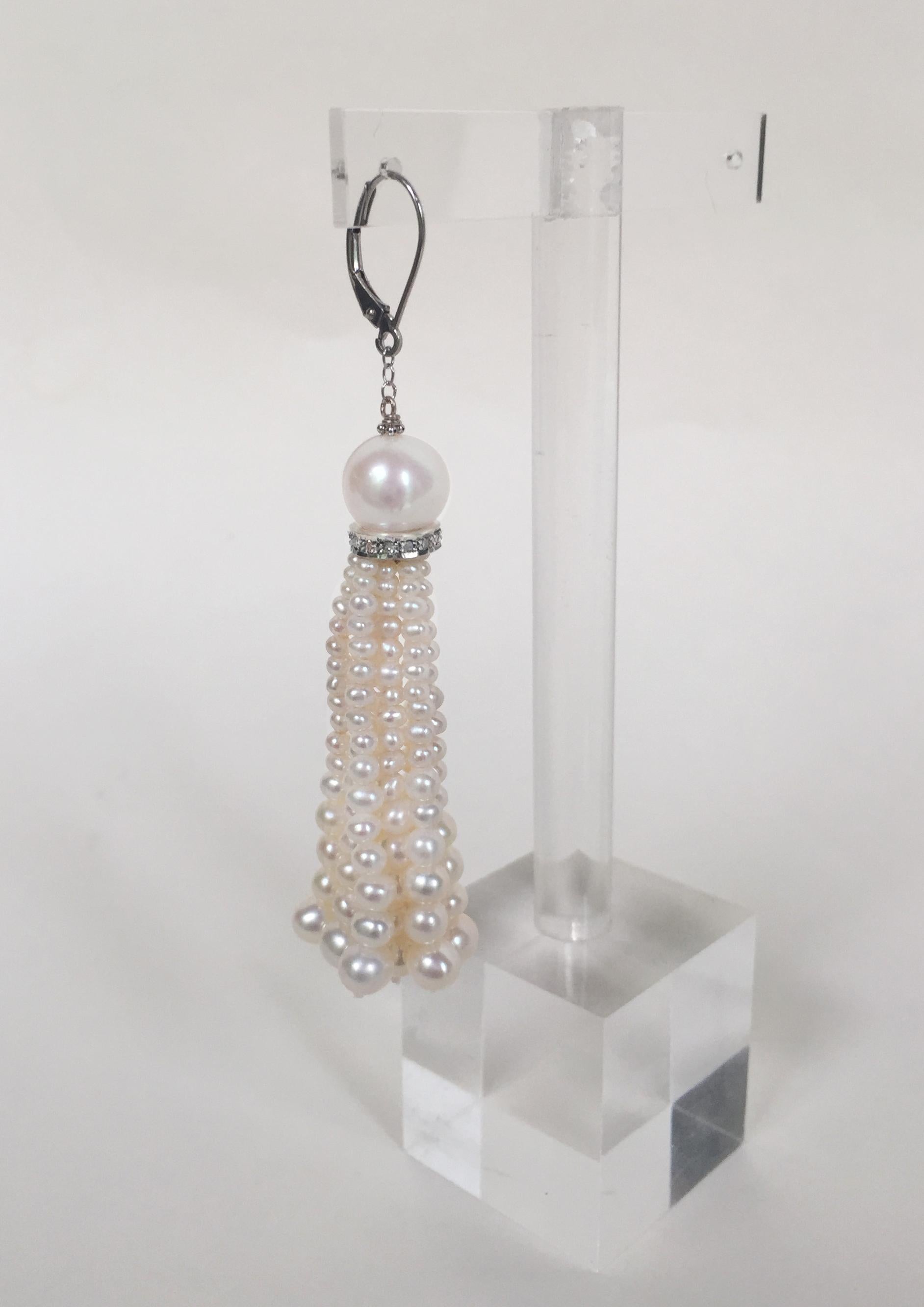 These white pearl tassel earrings with diamonds and 14k white gold lever backs are beautifully handcrafted by Marina J.   A round white pearl is nestled in a silver diamond-encrusted roundel, hanging from a small 14k white gold chain and lever