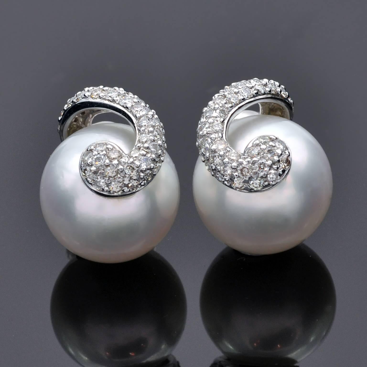 Elegant stud earrings : two 18 karat white gold curl motive set with 1.01 carat of diamonds which highlights two 12mm round white pearl.
