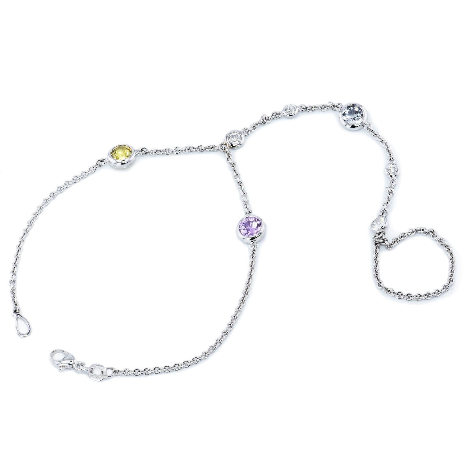 Let the beauty of this lariat bracelet capture you, with 18 karat white gold bezel stations featuring three sapphire stones (2.22 carats in total weight in white, yellow, and pink) and 0.46 carats in total weight of diamonds (G-H/VS1).