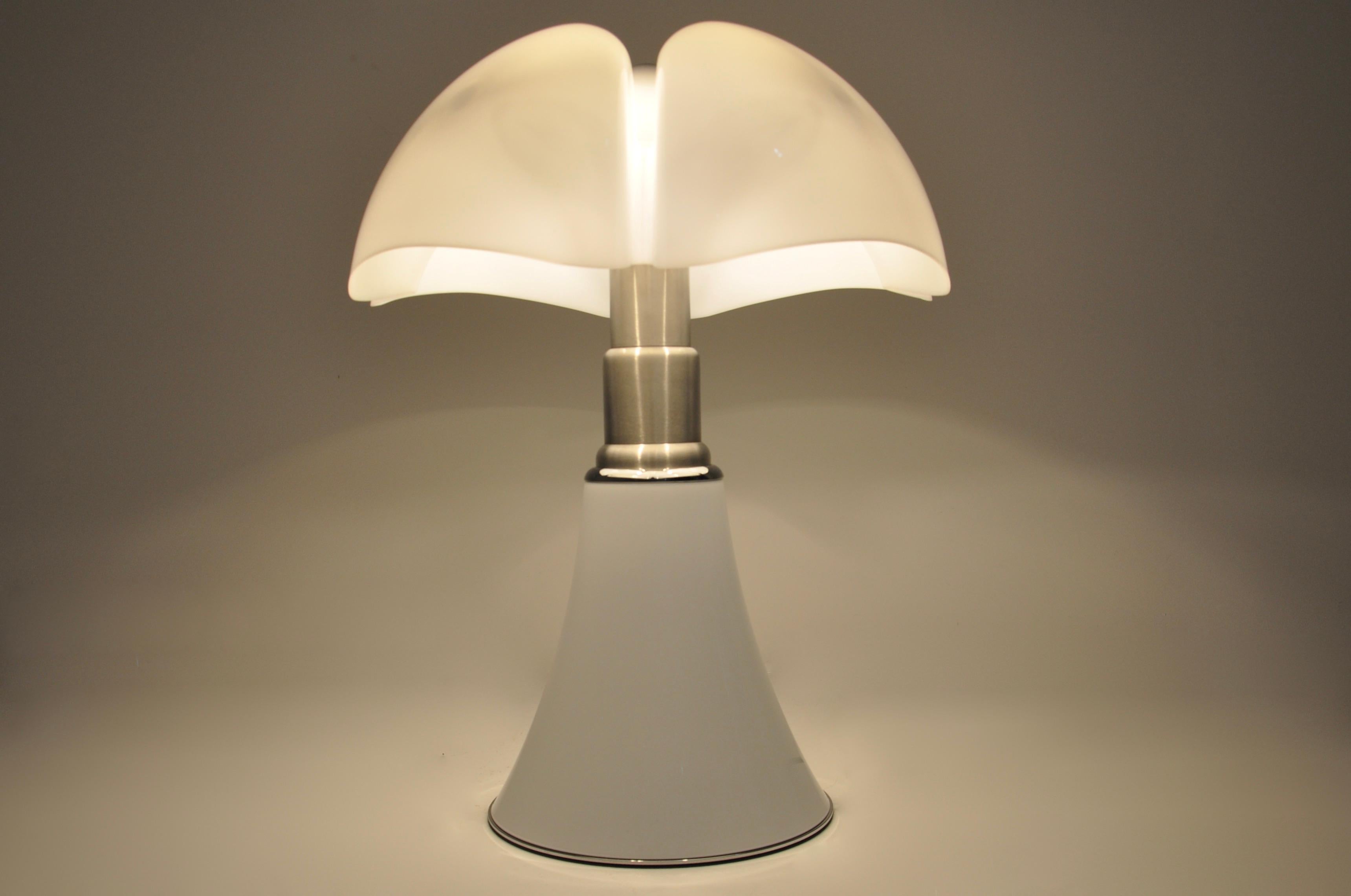 White lamp in metal and plastic by Gae Aulenti. Adjustable in height min: 70cm max: 90cm 
Stamped under the lamp.
Wear due to time and age of the lamp.
