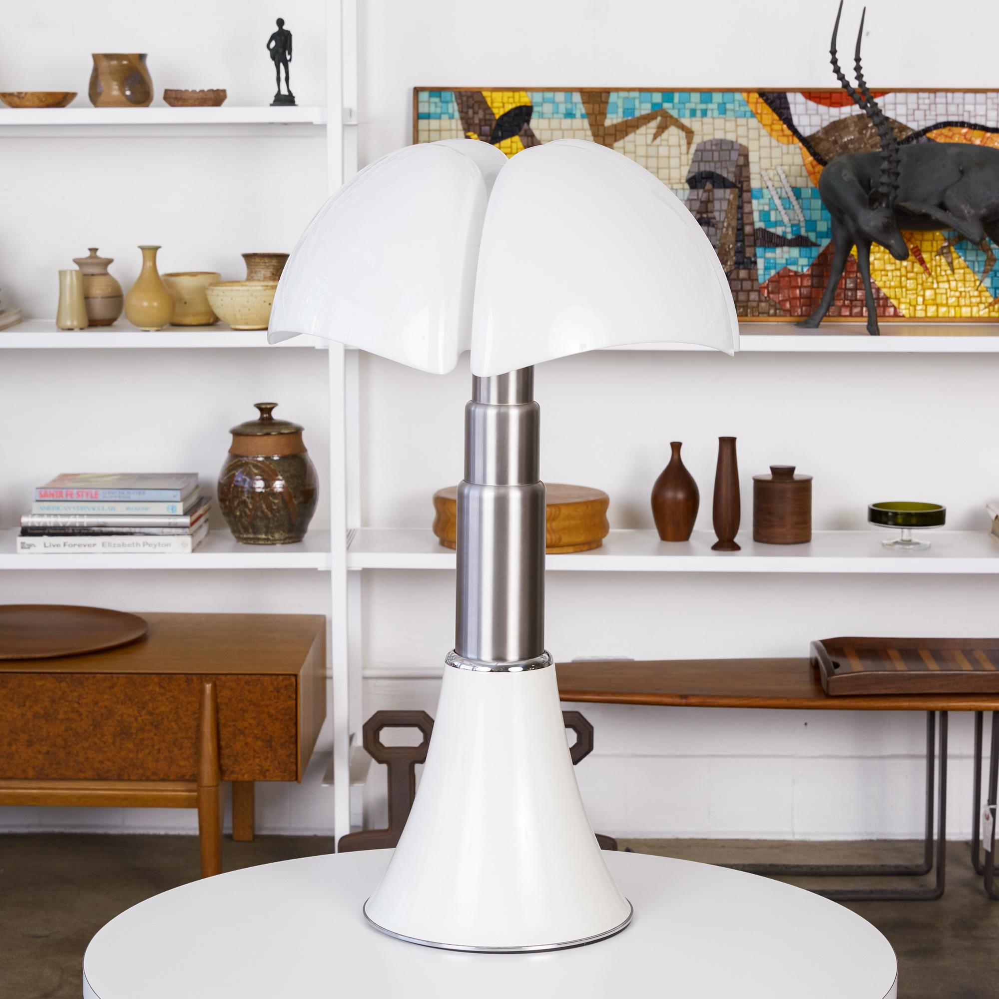 Pipistrello table lamp by Gae Aulenti for Martinelli Luce. The Model 620 lamp was designed in 1965 by the Italian design maestro and has remained a steadfast classic for generations. The lamp features a sculptural opal plastic shade, white painted