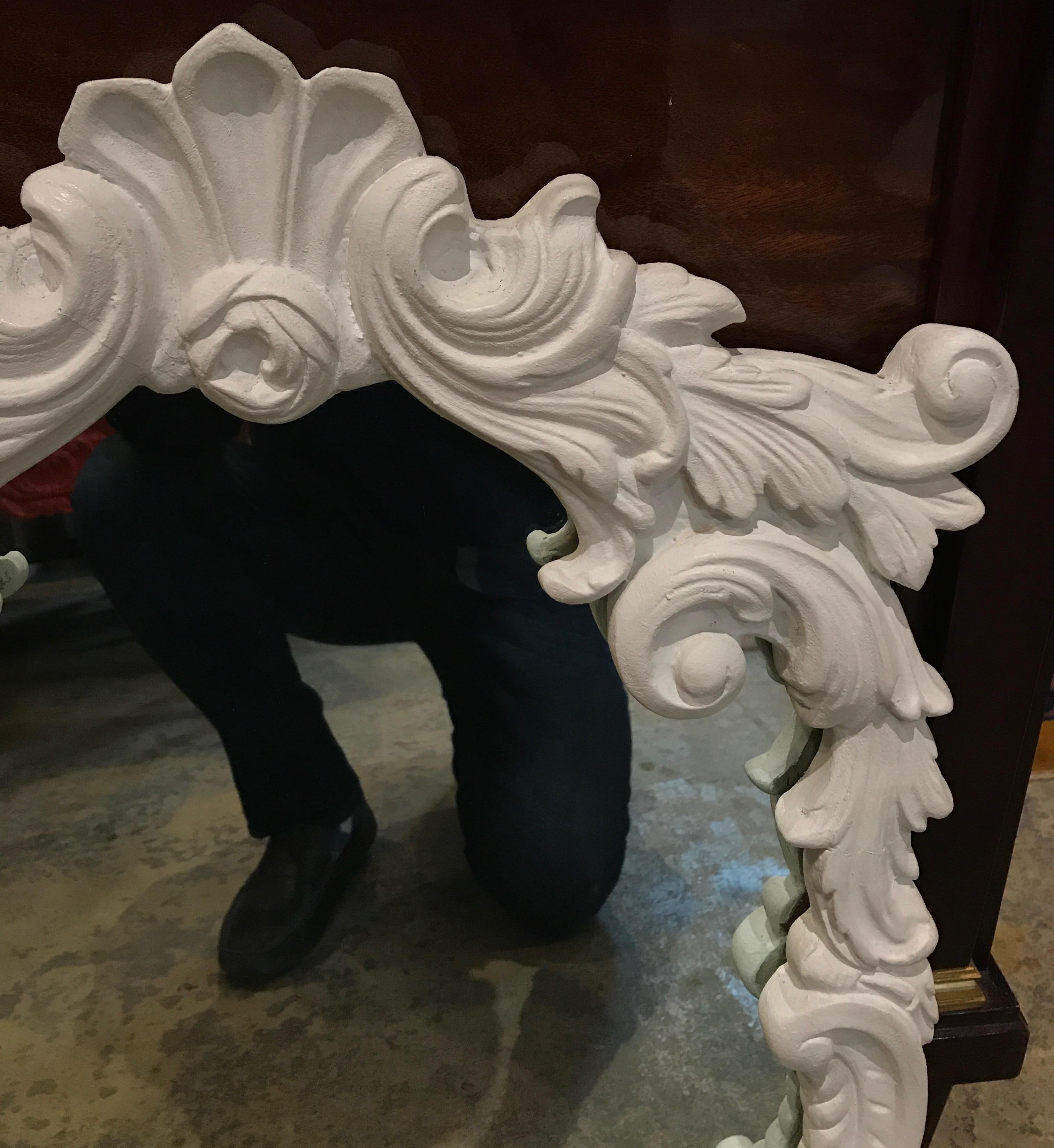 The frame of this mirror is made entirely from poured, molded plaster. The white floral and leafy themes elegantly sweep and flow around the frame in 3 dimensions.