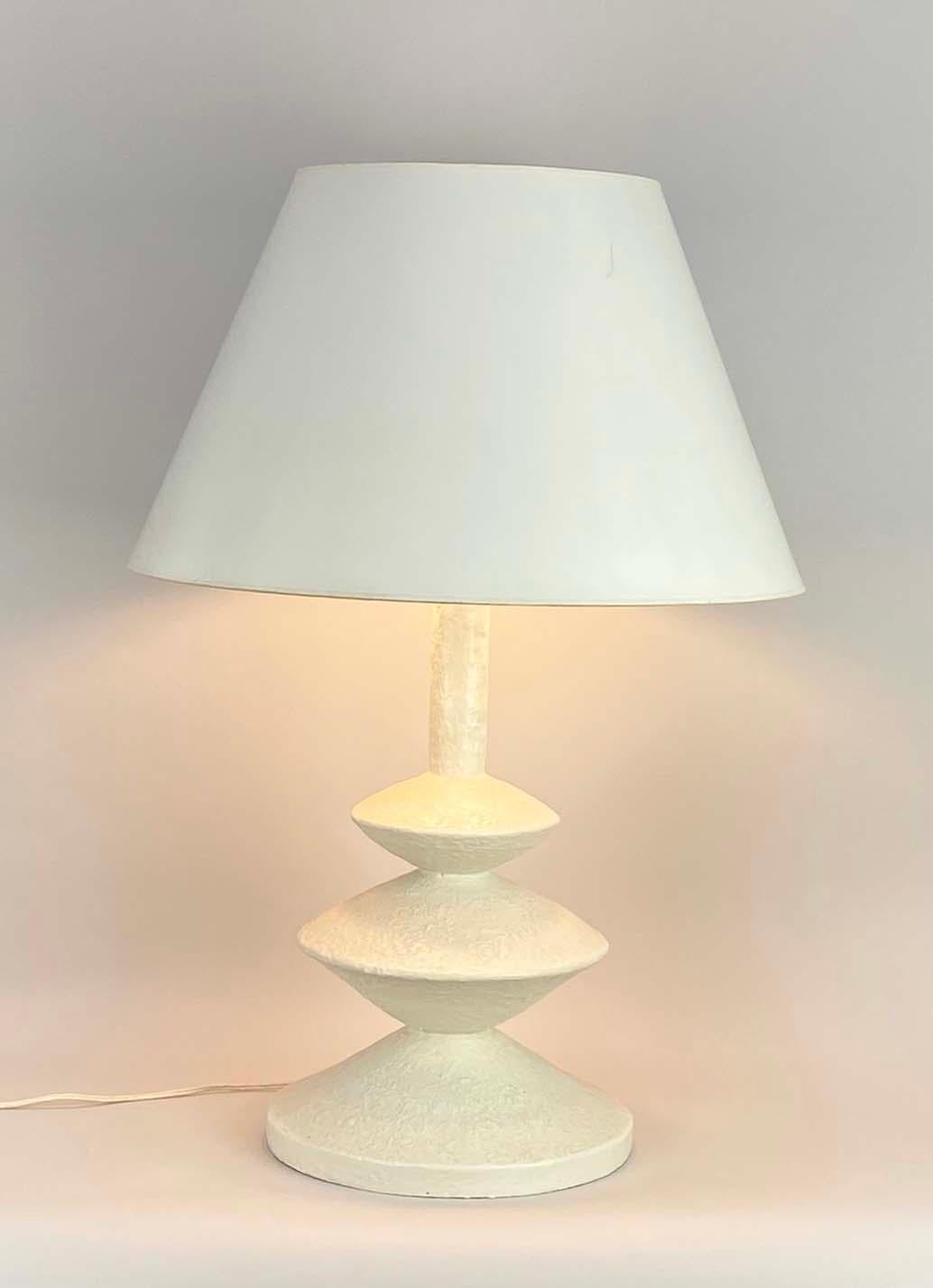 Here is an iconic white plaster lamp after Alberto Giacometti and Jean-Michel Frank manufactured by Sirmos in the 1970s. The lamp is in very good condition with no chips, cracks or repairs--but has some soiling and minor discoloration consistent