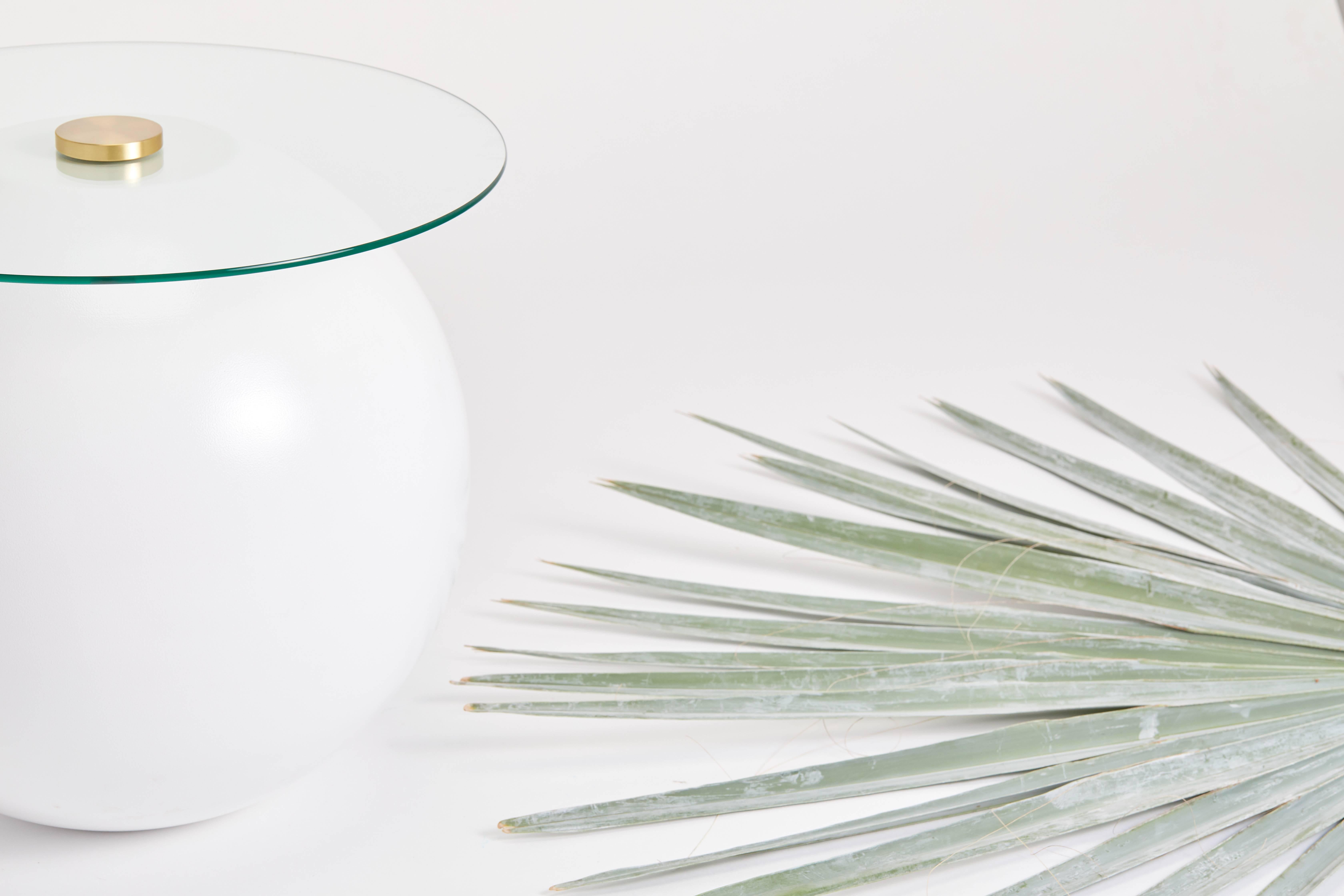 A coffee table suitable for both indoor and outdoor use. The base is constructed from two hand spun hemispheres perfectly married together. The top is secured via an oversized bolt. The base is pictured in a white powder coat with clear