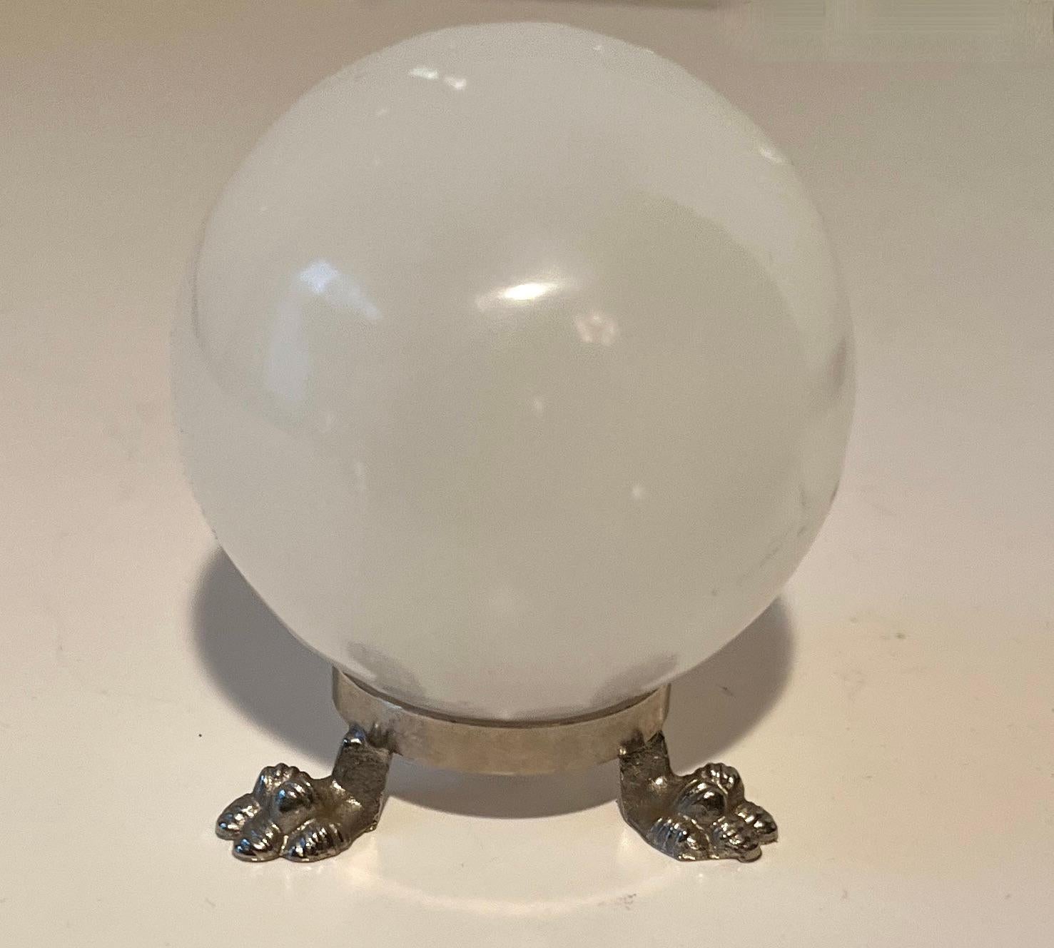 A lovely, small White Quartz Tigers eye Ball on top of a Silver Stand with paw feet.

The paperweight is a great decorative piece and on a very nice little stand.  Could be used as a paperweight too!  

Small and a compliment to many areas or