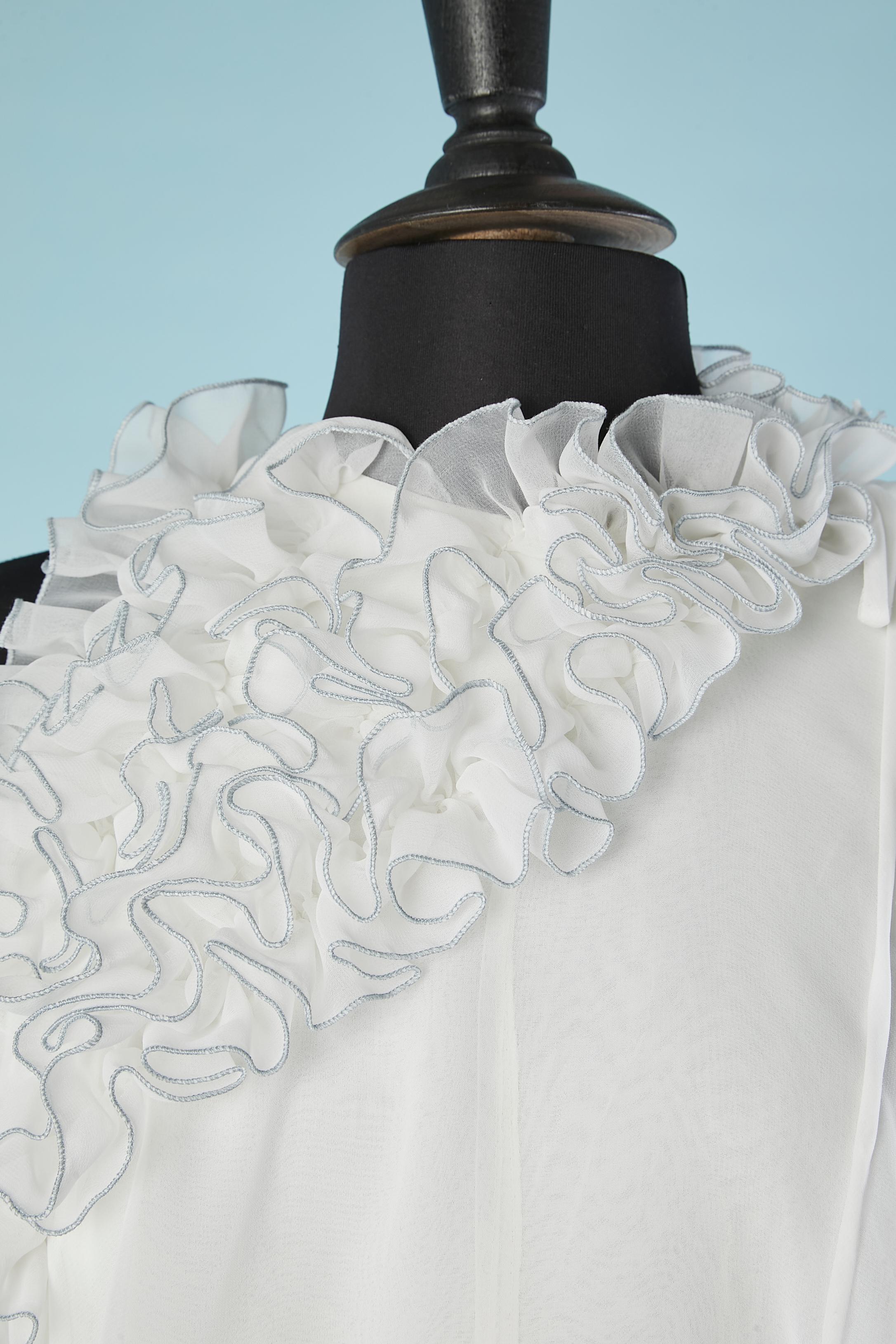 Robe de soirée asymétrique en mousseline de polyester blanche avec volants et pompons de fleurs.
Fermeture éclair sur le côté gauche et boutons-pression sur l'épaule gauche. 
TAILLE M