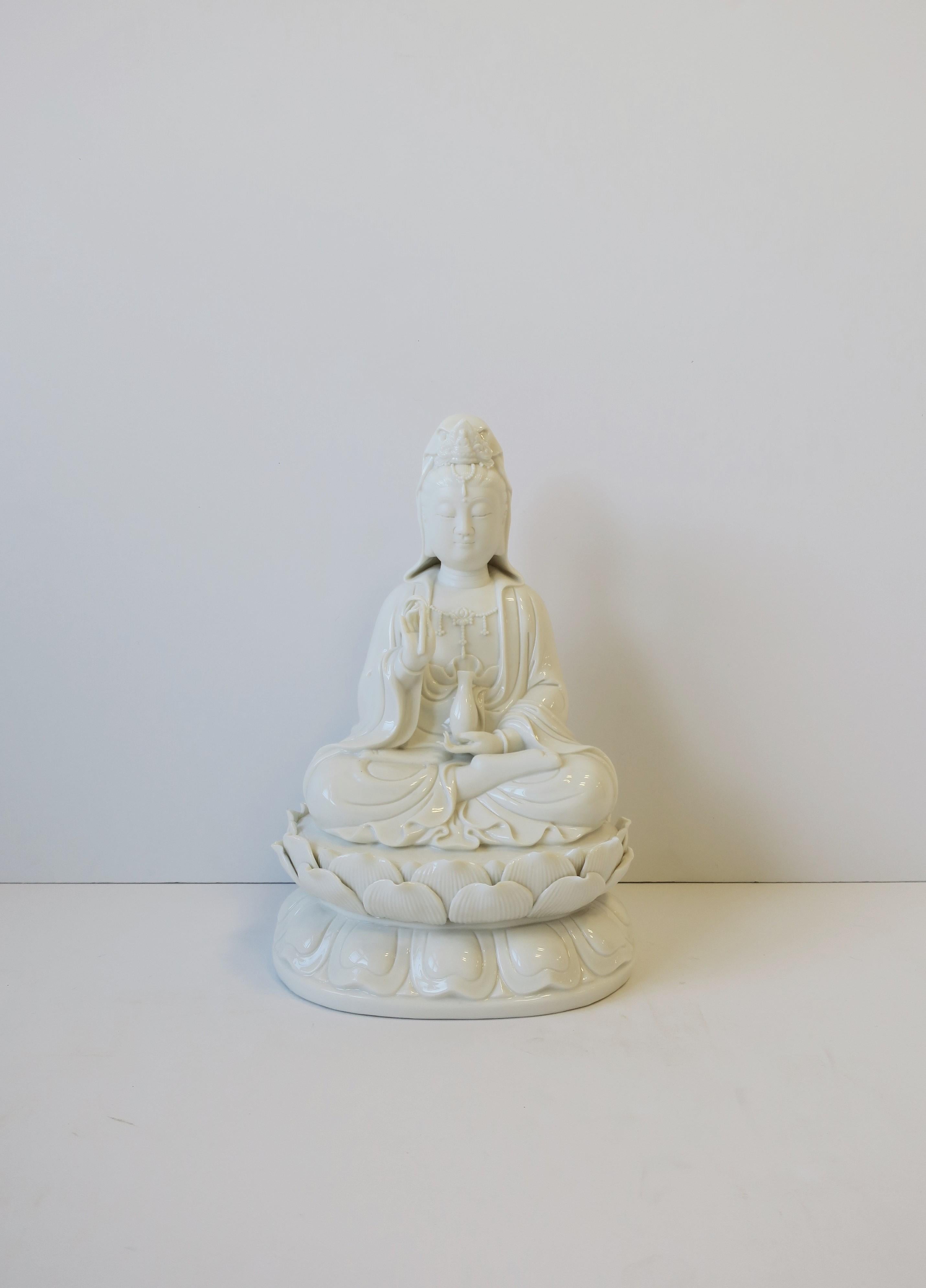 A white porcelain Buddha, circa late-20th century, Asia. Buddha, relatively large, sitting in meditating position with lotus leaves surrounding base. There are several special characteristics of a Buddha; specific to this Buddha they include a