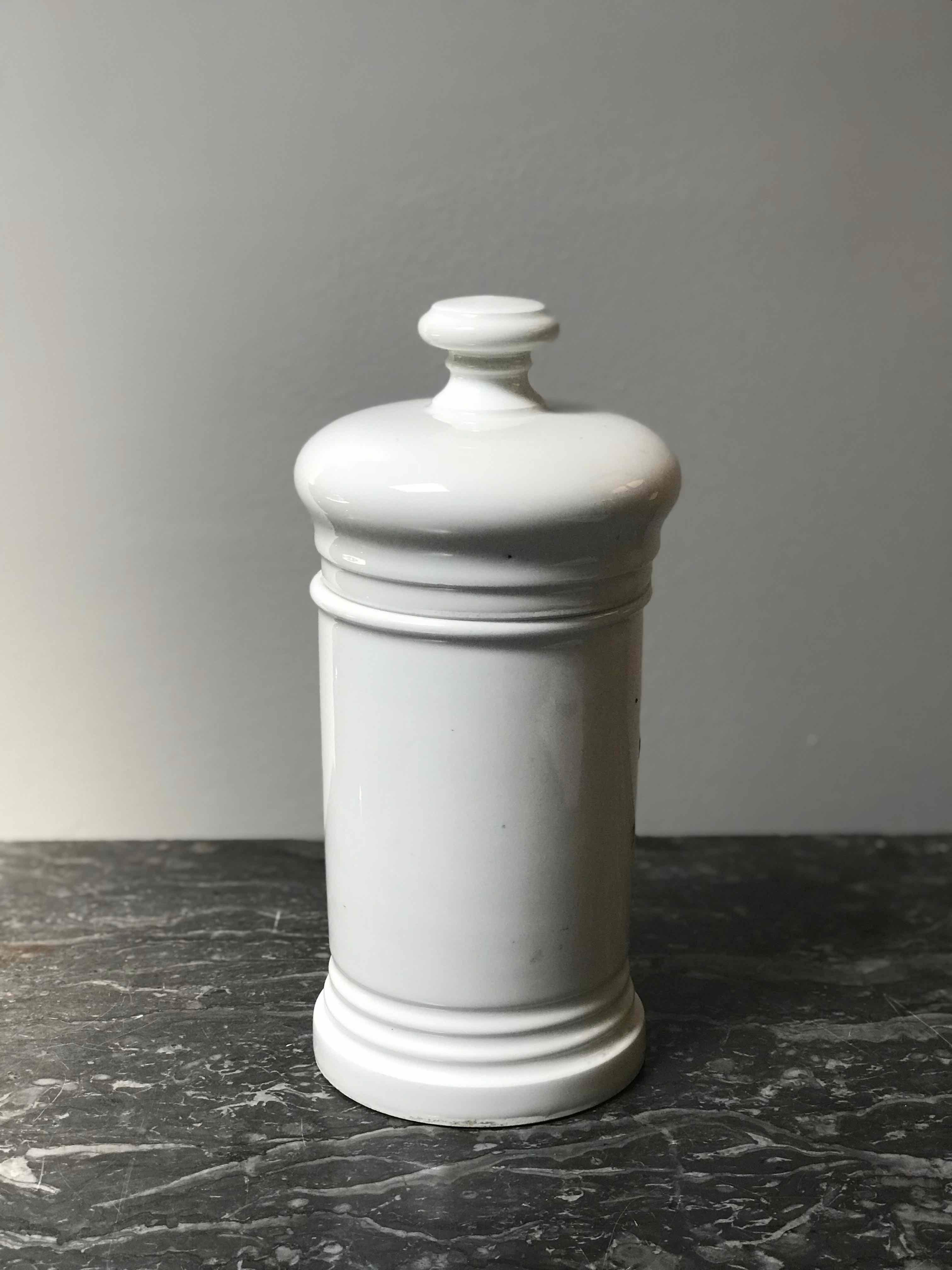 A white porcelain canister from an herb dispensary.