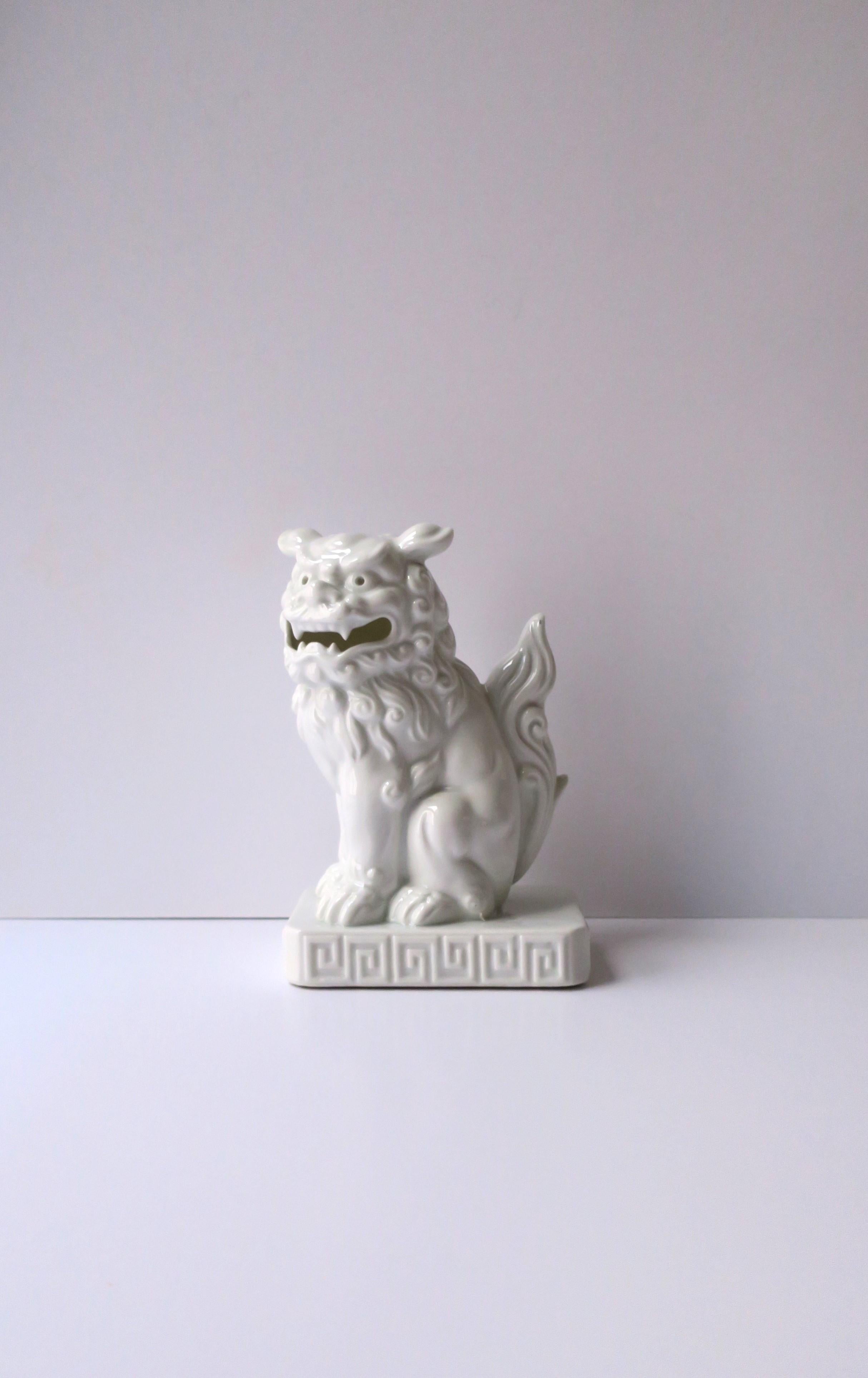 A beautiful white porcelain foo dog lion decorative object or bookend, circa early to mid-20th century, Japan. Foo dog lions, also known as komainu in Japan, are a symbol of good luck and protection. A great decorative object for a shelf, library,