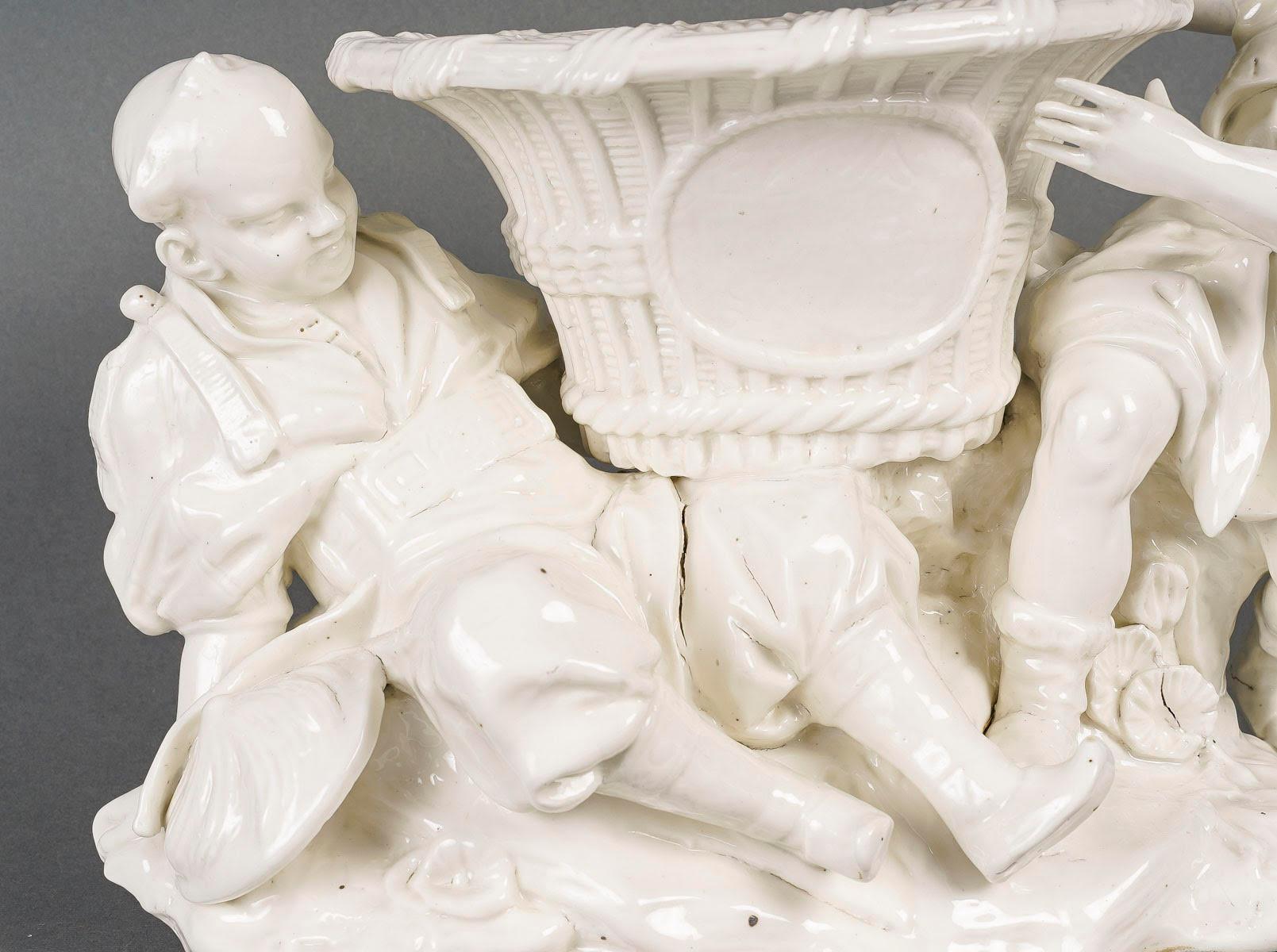 White Porcelain Jardinière, Chinese style, early 20th century.

Early 20th century white porcelain chinoiserie planter, centrepiece, depicting two figures surrounding the flowerpot and highlighting it, a beautiful presentation for a centrepiece.
h: