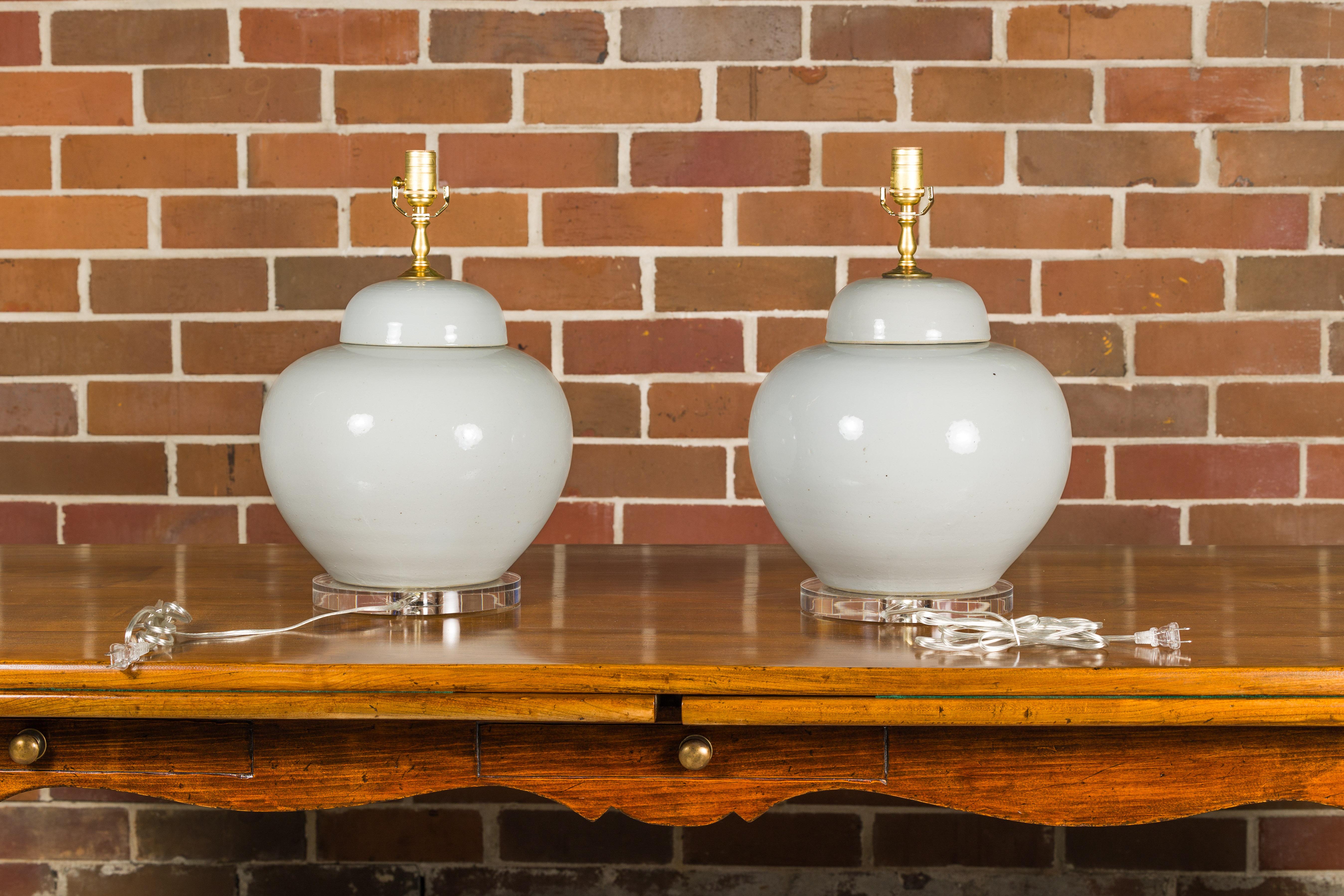 20th Century White Porcelain Lidded Urns Made into Wired Table Lamps on Lucite Bases, a Pair For Sale