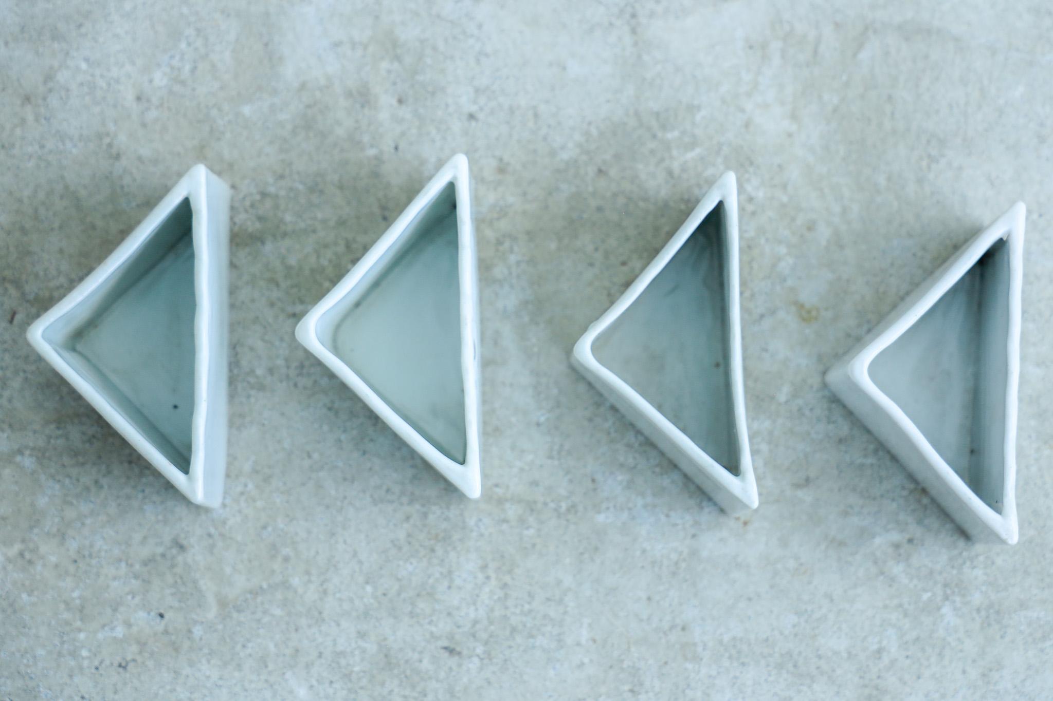 This is an antique triangular white porcelain vessel set made during the Showa period.

It features the soft texture and smooth surface unique to white porcelain, and a wavy curved design on one side.

Its small size makes it versatile and can be