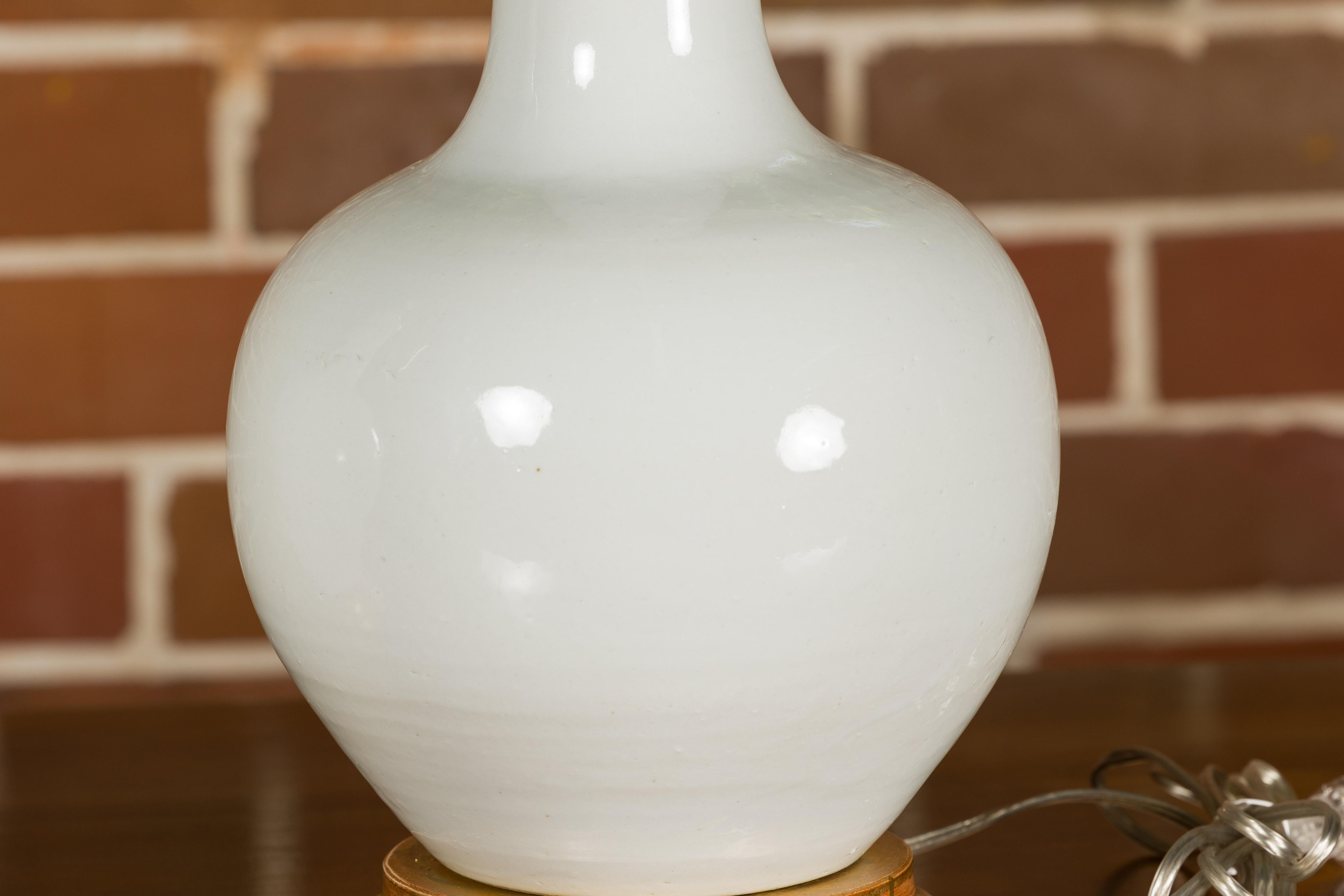 Paire de vases en porcelaine blanche transformés en lampes de table câblées sur bases en bois doré en vente 5