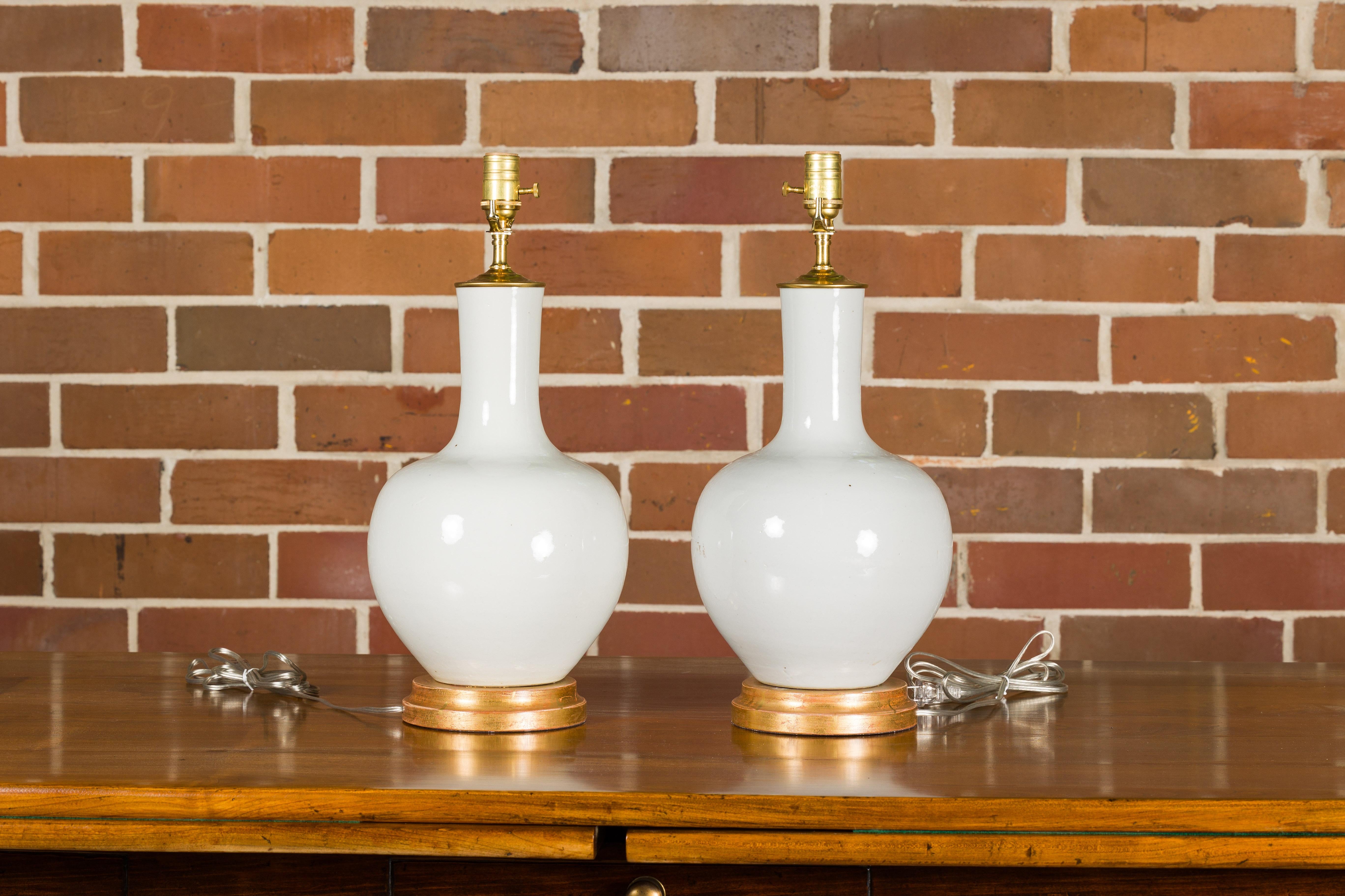 Asian White Porcelain Vases Made into Wired Table Lamps on Giltwood Bases, a Pair