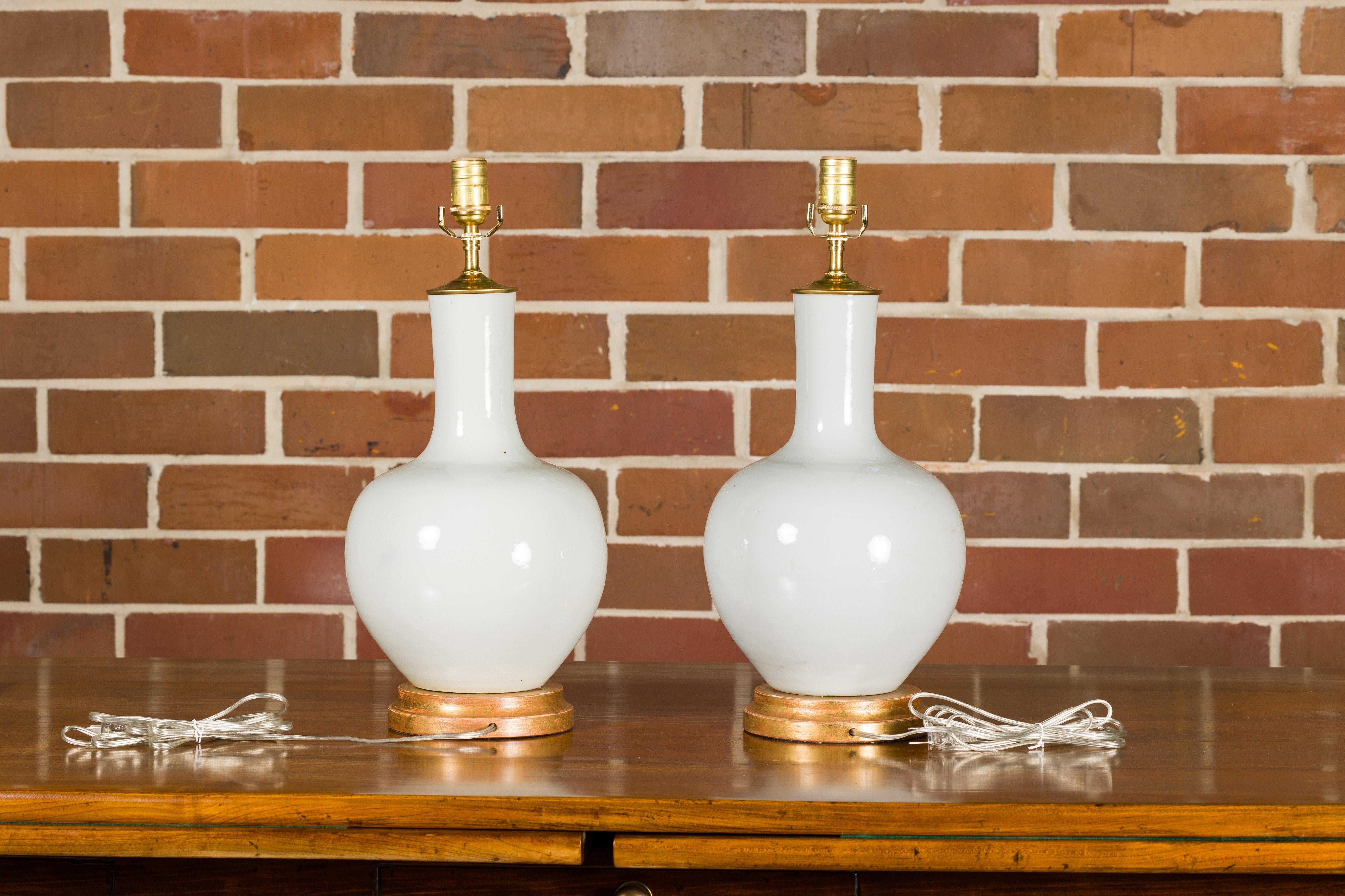 White Porcelain Vases Made into Wired Table Lamps on Giltwood Bases, a Pair In Good Condition In Atlanta, GA