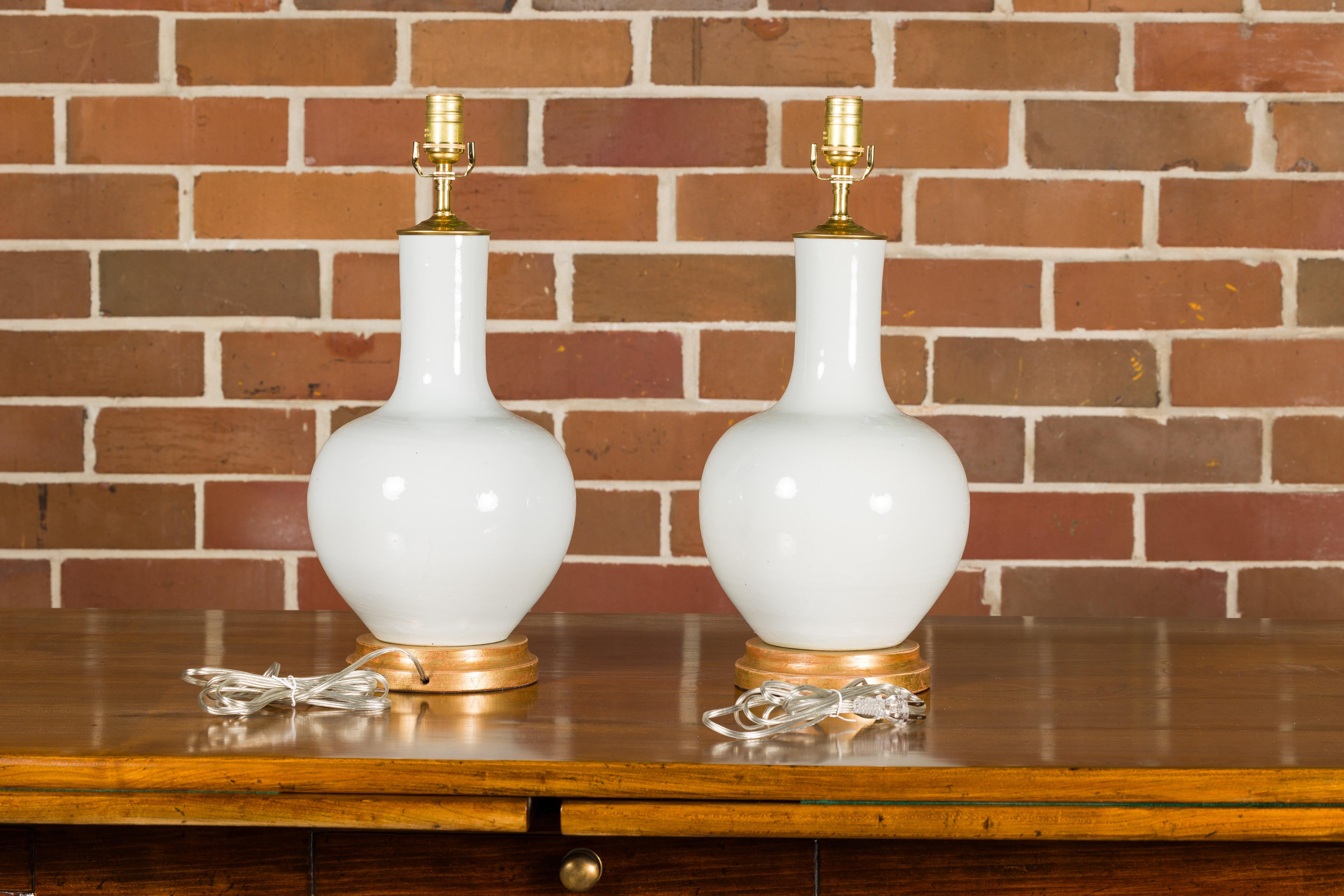 White Porcelain Vases Made into Wired Table Lamps on Giltwood Bases, a Pair In Good Condition For Sale In Atlanta, GA
